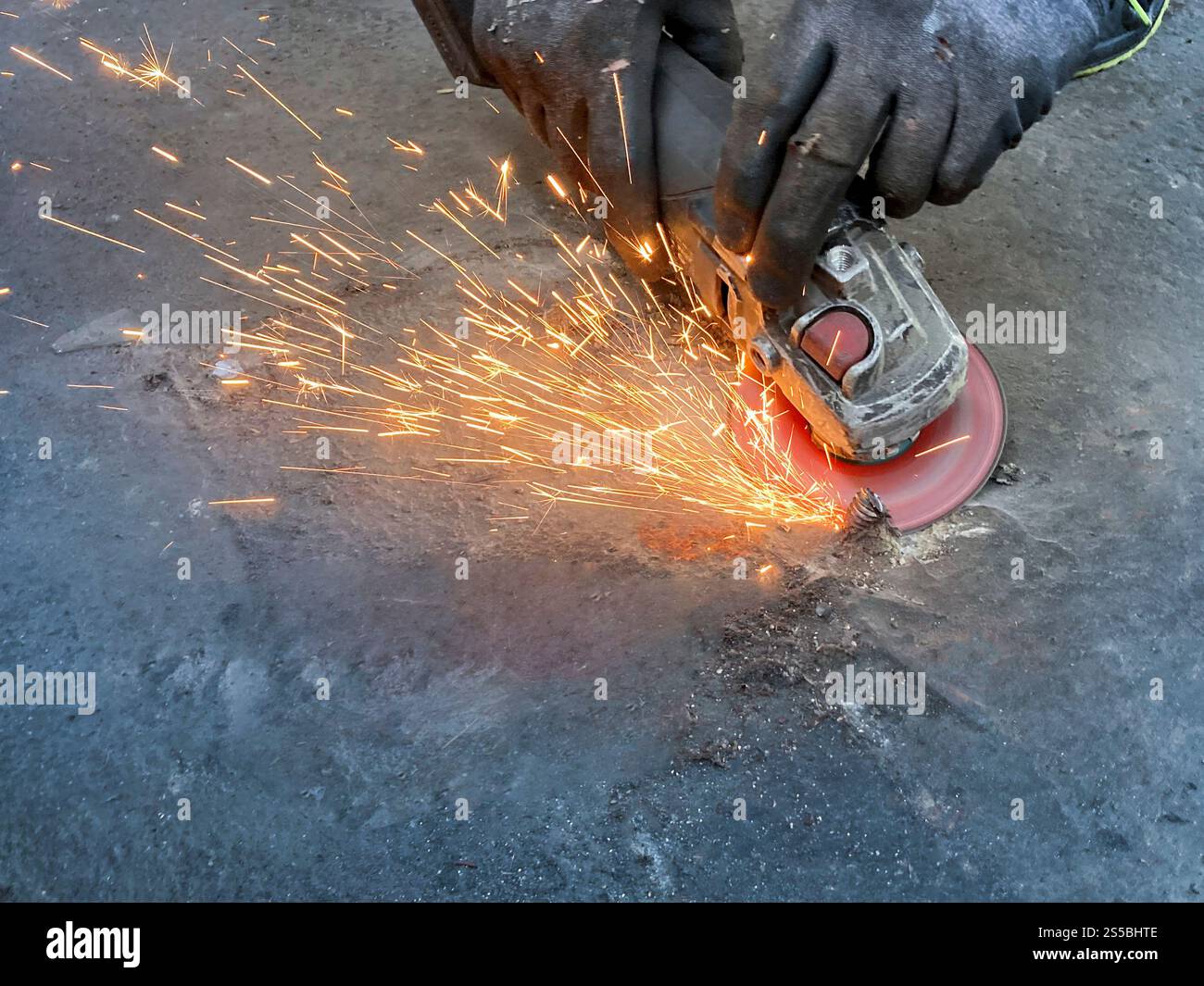 Arbeiter, der Metallprofile mit elektrischem Winkelschleifer schneidet - Smartphone-aufgenommenes Stockfoto