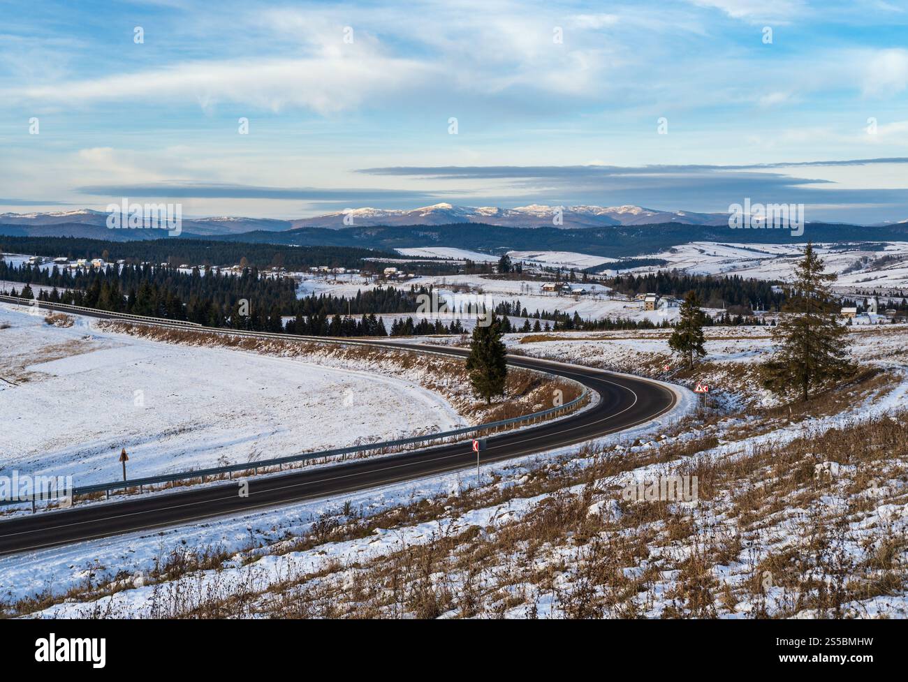 Asphaltstraßenkurve und Winter beginnend in den Bergen, der Ukraine, den Karpaten. Stockfoto