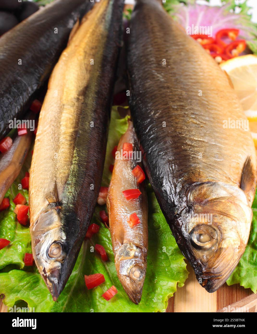 Fisch auf Teller mit rotem Pfeffer in Nahaufnahme. Fisch auf Teller mit rotem Pfeffer Stockfoto