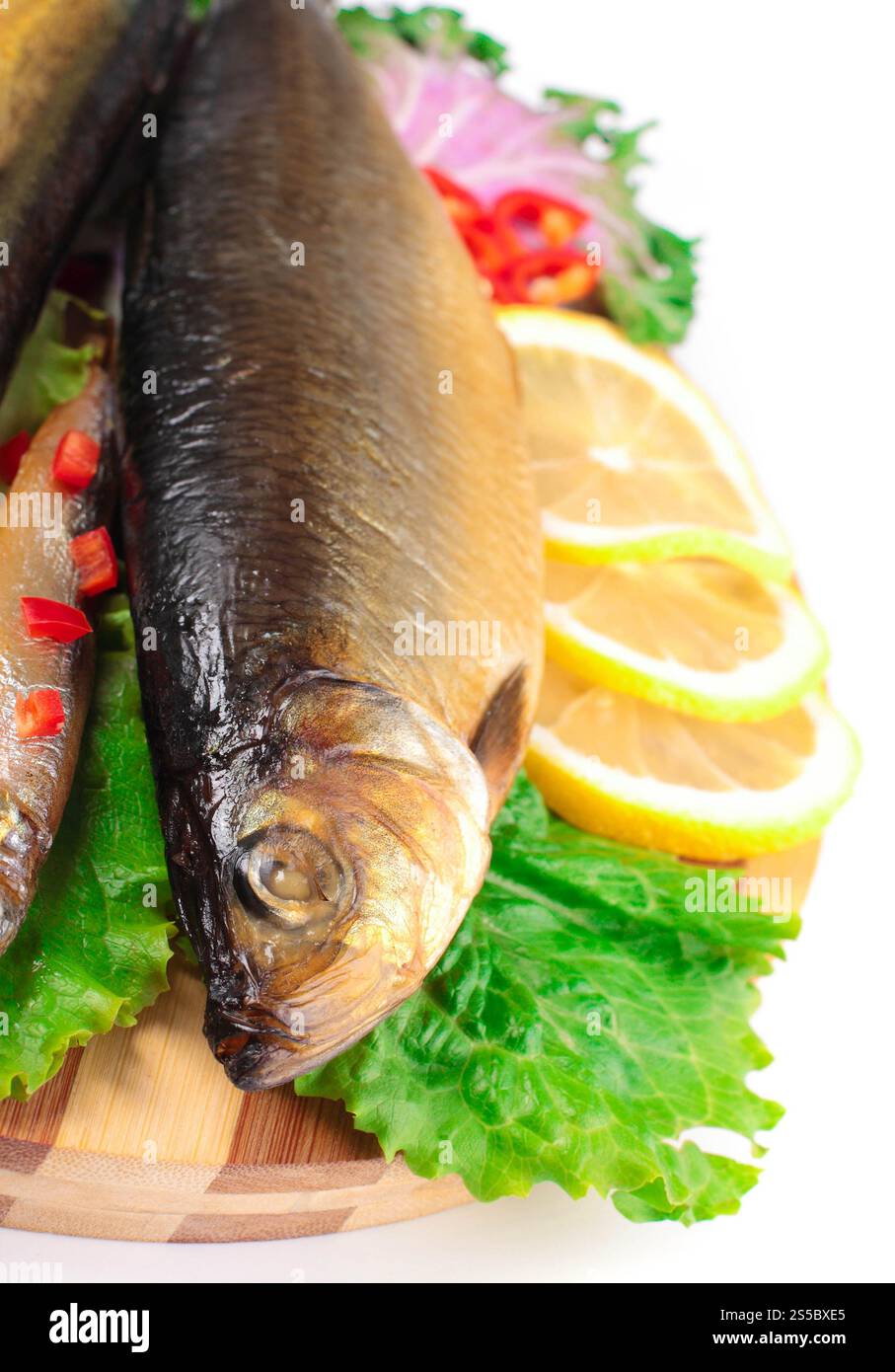 Fisch mit Zitrone auf Teller isoliert auf weißem Hintergrund. Fisch mit Zitrone auf Teller Stockfoto