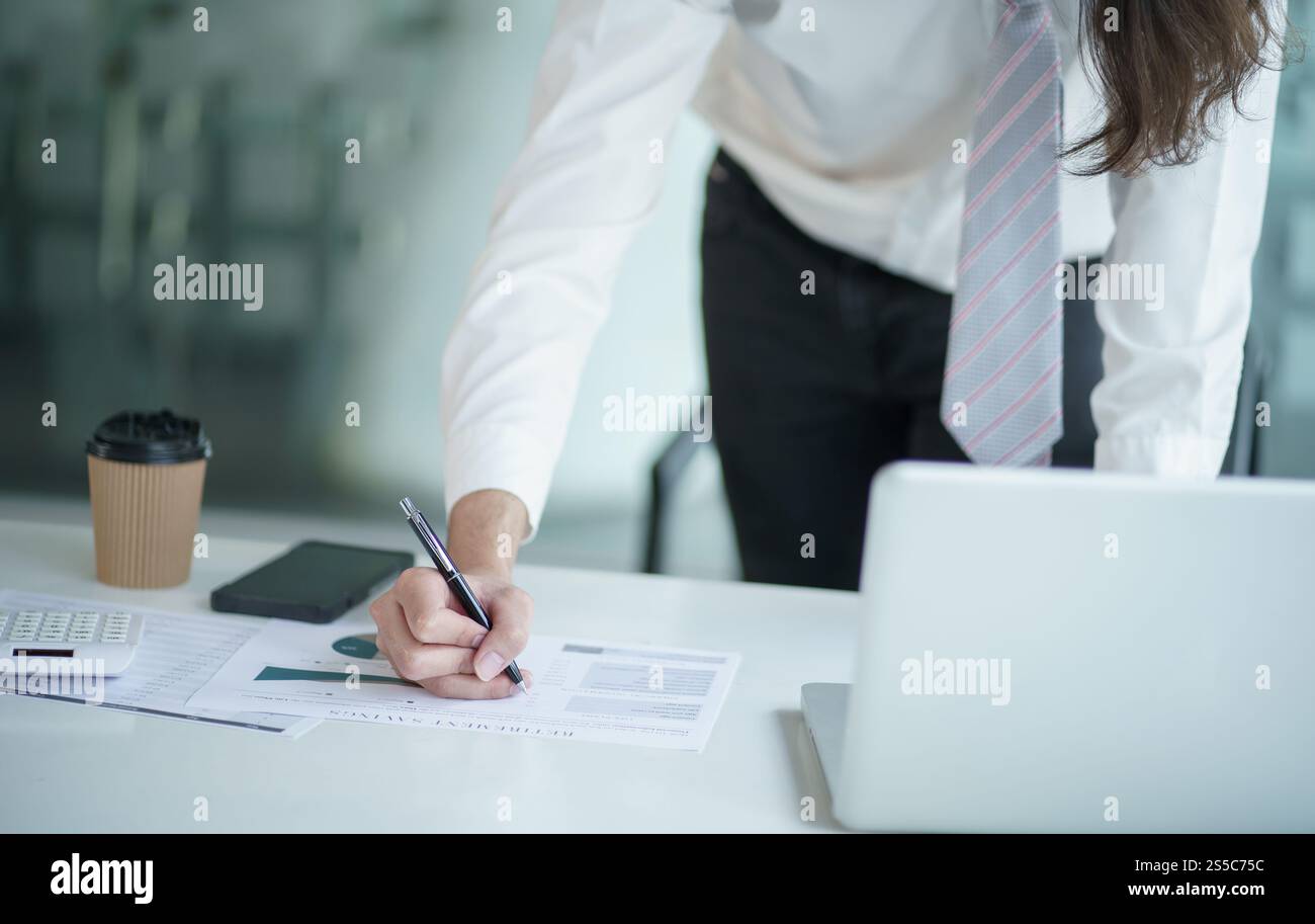 Junger Geschäftsmann, der im Büro arbeitet. Geschäftsmann, der Finanzpapierarbeit im Geschäftsbetrieb macht Stockfoto