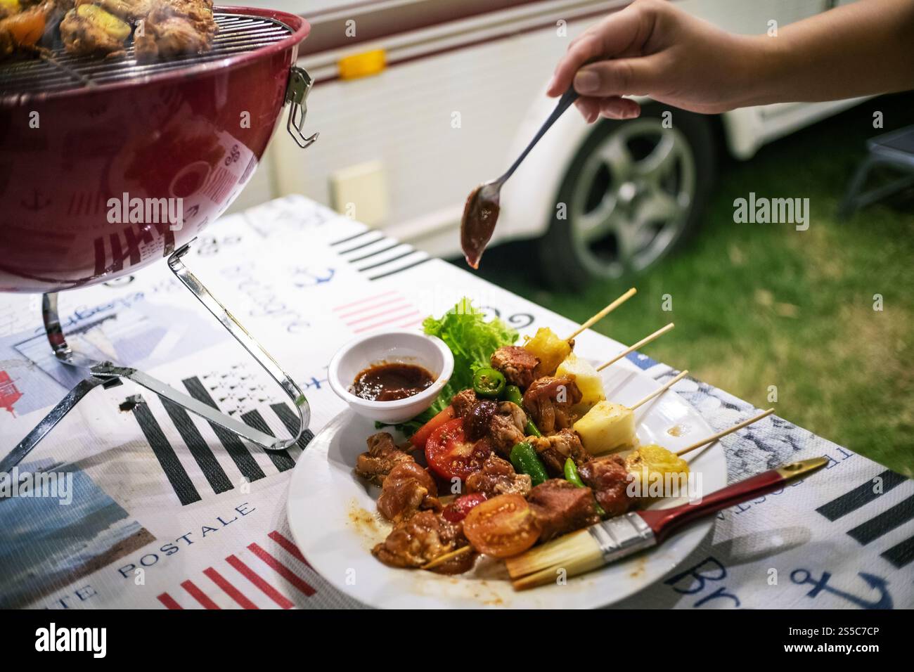Freunde machen Barbecue BBQ Grillen über einem heißen Feuer in der Natur. Abendparty Stockfoto