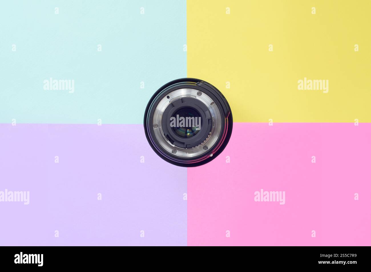 Minimalismus mit fotografischer Linse auf blauem, violettem, rosa und gelbem Hintergrund. Trendige Pastellfarben. Draufsicht mit flacher Lage. Minimalismus mit Fotografie Stockfoto