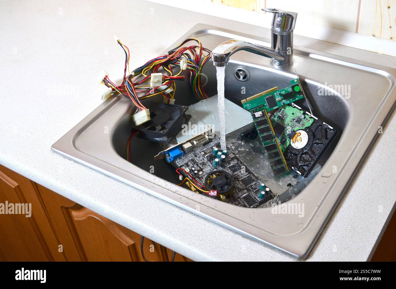 Hardware-Konzept reinigen. Waschen des Mainboards, der Festplatte und des Computernetzteils im Spülbecken. Auch ein Symbol für einen großen Fehler. Stockfoto