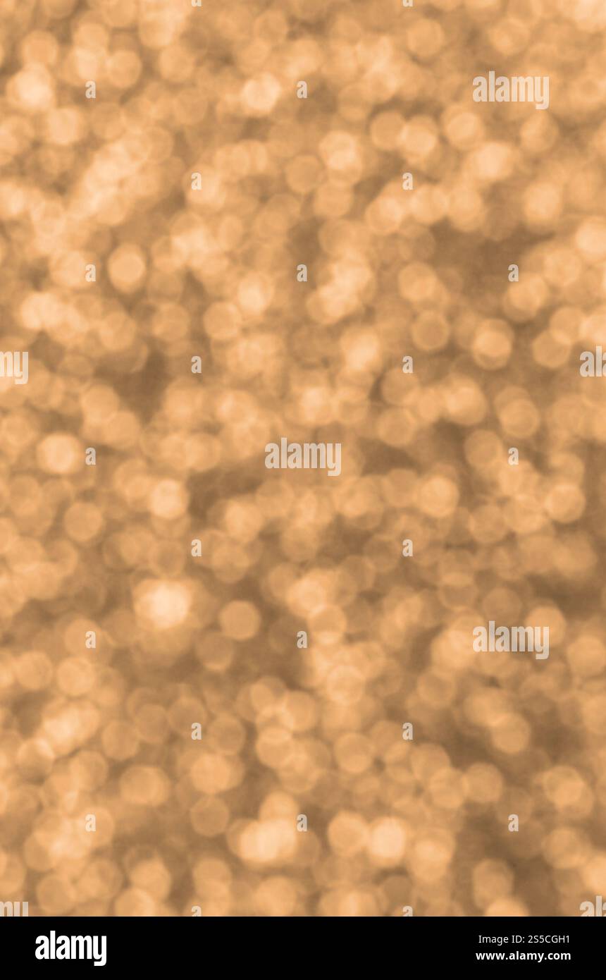 Verwischte orangefarbene dekorative Pailletten. Hintergrundbild mit glänzenden Bokeh-Lichtern von kleinen Elementen, die Licht reflektieren. Deko in verwischtem Orange Stockfoto