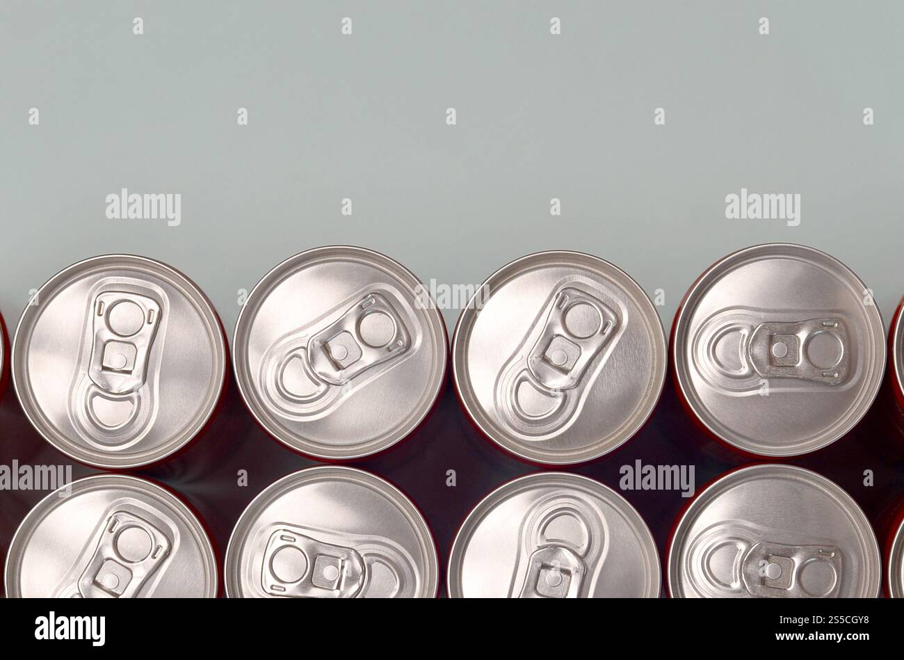 Viele neue Aluminiumdosen mit alkoholfreien Limonaden, Limonade Cola, Bier oder Energy Drink. Konzept der Getränkeherstellung und Massenproduktion. Viele Stockfoto