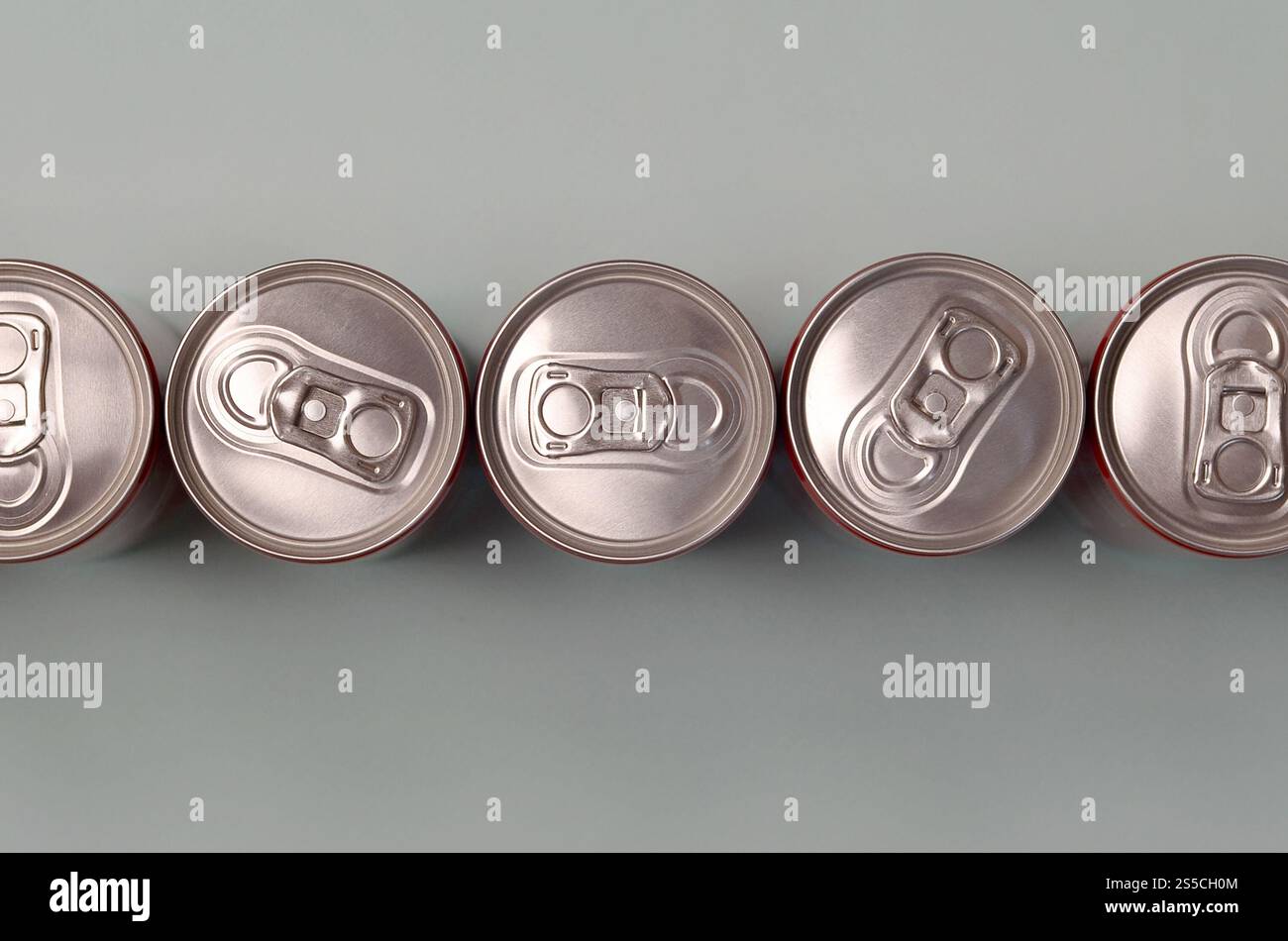 Viele neue Aluminiumdosen mit alkoholfreien Limonaden, Limonade Cola, Bier oder Energy Drink. Konzept der Getränkeherstellung und Massenproduktion. Viele Stockfoto