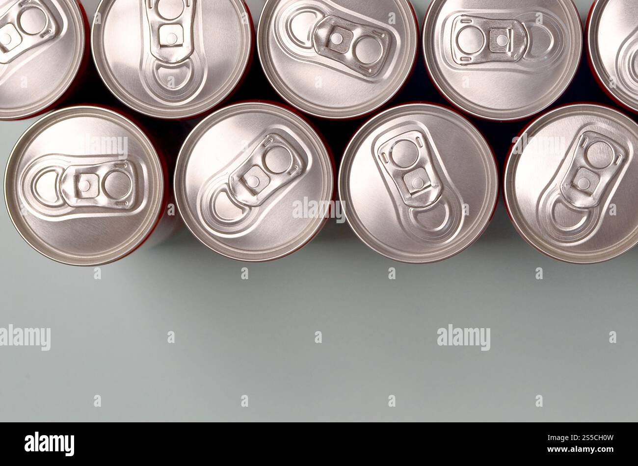 Viele neue Aluminiumdosen mit alkoholfreien Limonaden, Limonade Cola, Bier oder Energy Drink. Konzept der Getränkeherstellung und Massenproduktion. Viele Stockfoto