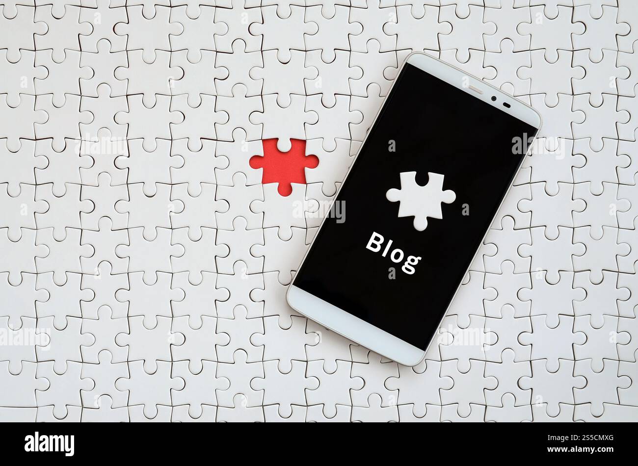 Eine moderne grosse Smartphone mit Touchscreen liegt auf einem weißen Puzzle im zusammengebauten Zustand mit Inschrift. Blog Stockfoto