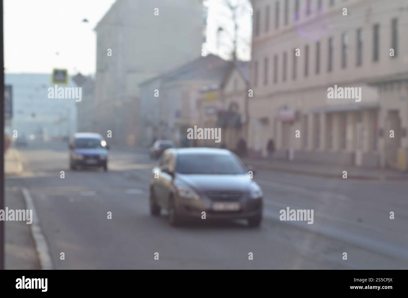 Die verschwommene Landschaft der Stadtstraßen mit fahrenden Autos an einem nebeligen Morgen. Künstlerische Rezeption eines verschwommenen Landschaftsfotos mit Bokeh-Effekt. Stockfoto