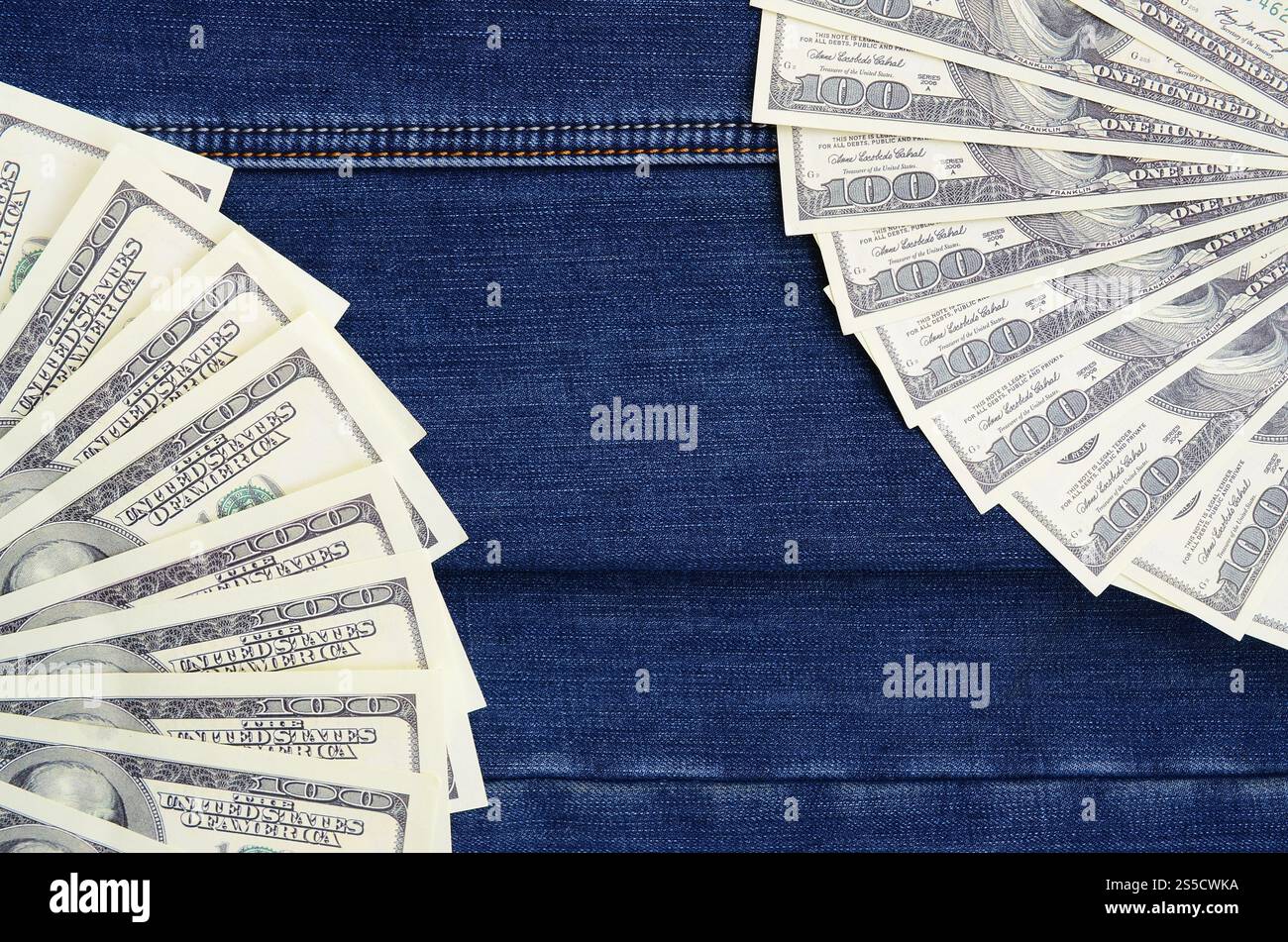 Der Fan einer Menge US-Dollar ist auf einer dunklen Jeansfläche. Hintergrundbild Stockfoto