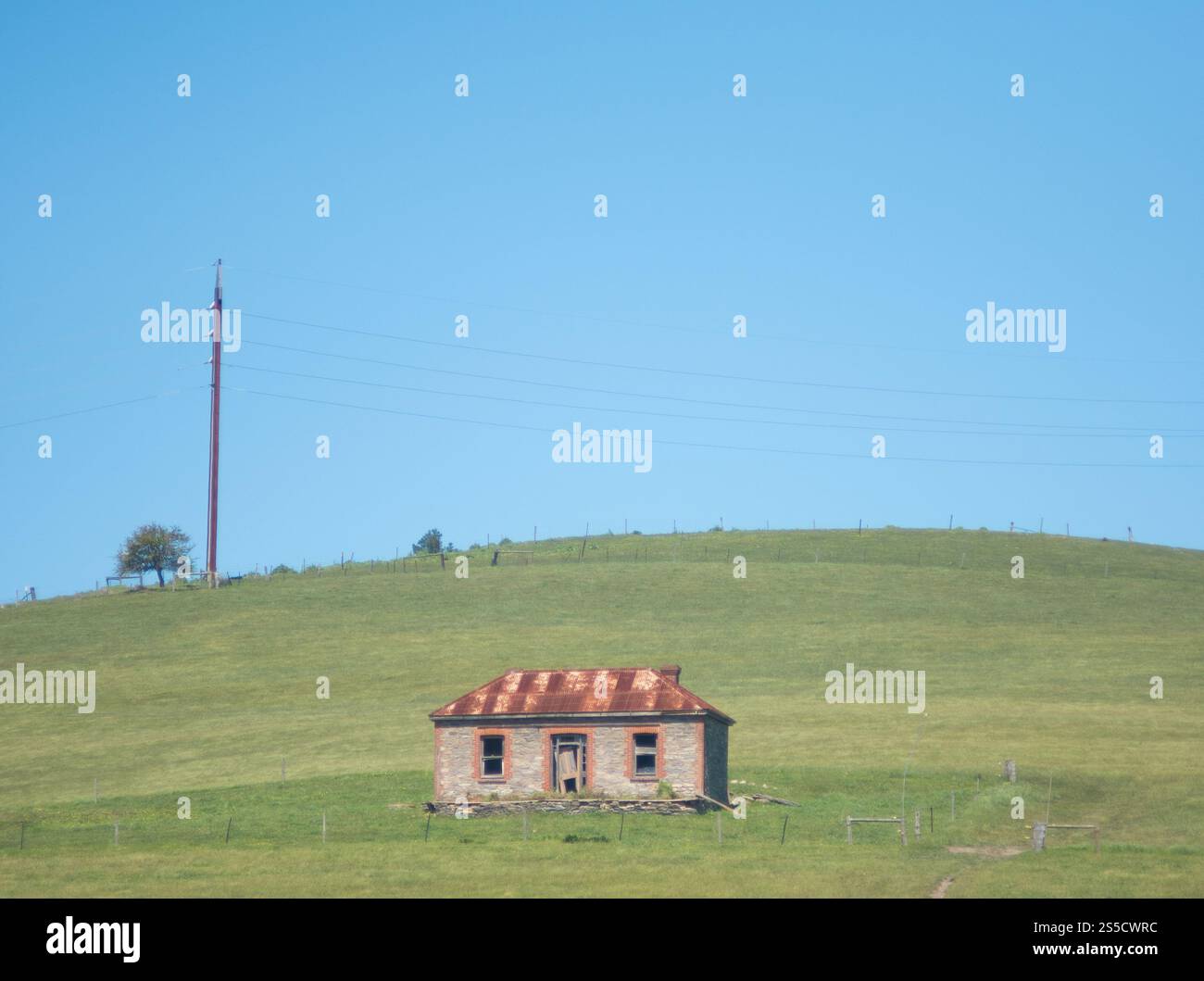Blick auf das alte Steinhaus am Fuße des grünen Hügels auf der Fleurieu Peninsula, South Australia, Australien. Stockfoto