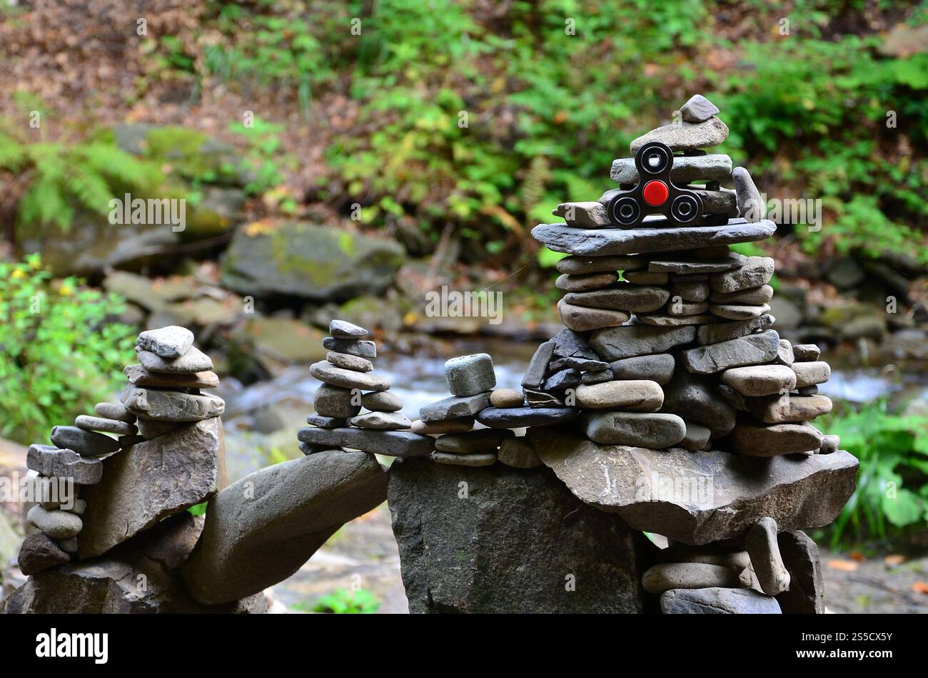 Eine hölzerne Spinner liegt auf seltsame Stein Strukturen im Wald Stockfoto