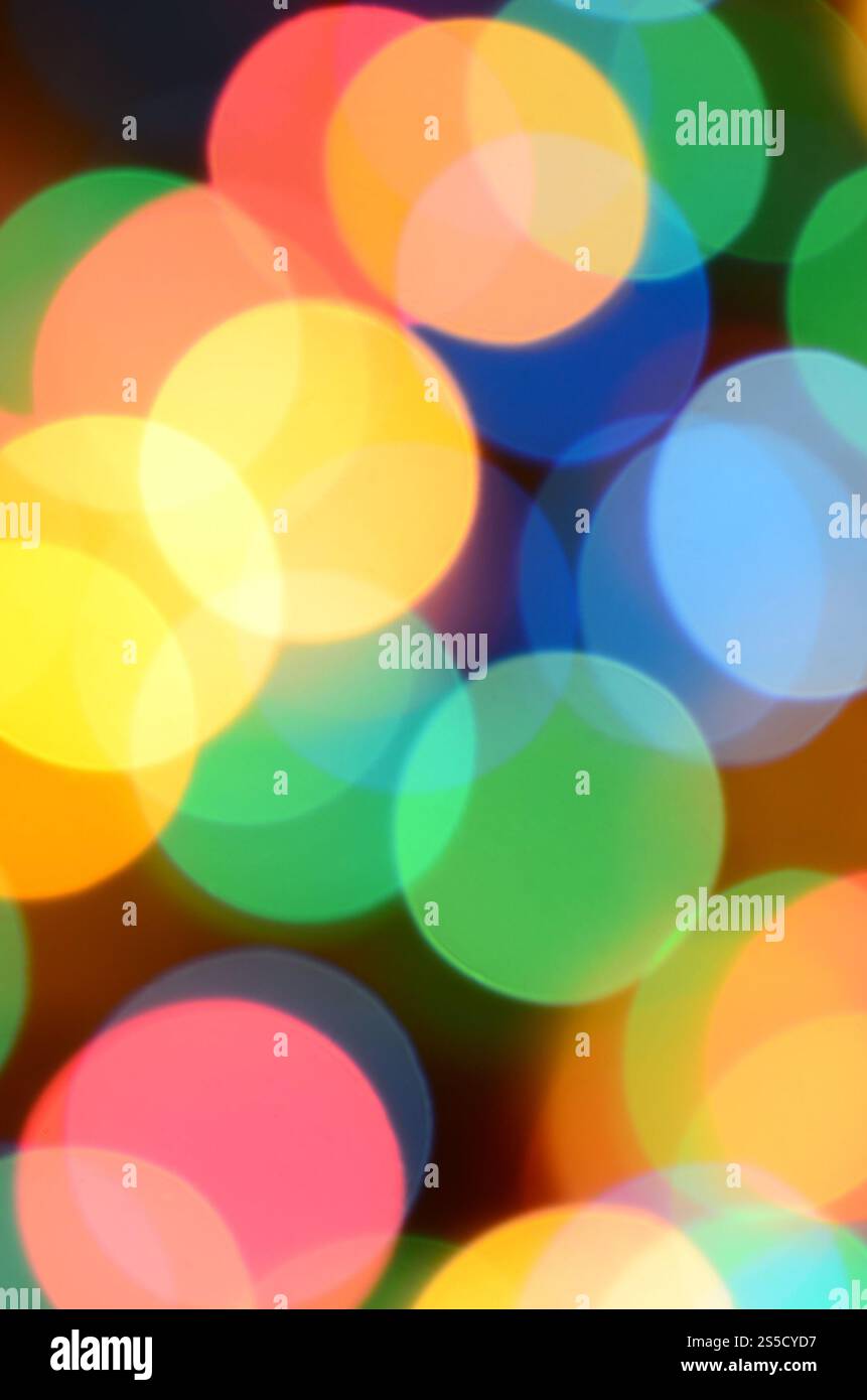Verschwommene festliche bunte Lichter über Schwarz als Hintergrund nützlich. Alle Hauptfarben enthalten. Rot, Gelb, Grün und Blau Stockfoto