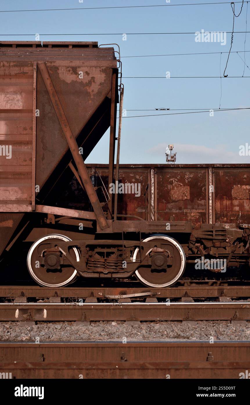 Detailliertes Foto des Güterwagens. Ein Fragment der Bauteile des Güterwagens auf der Schiene bei Tageslicht. Teile des Güterwagens Stockfoto