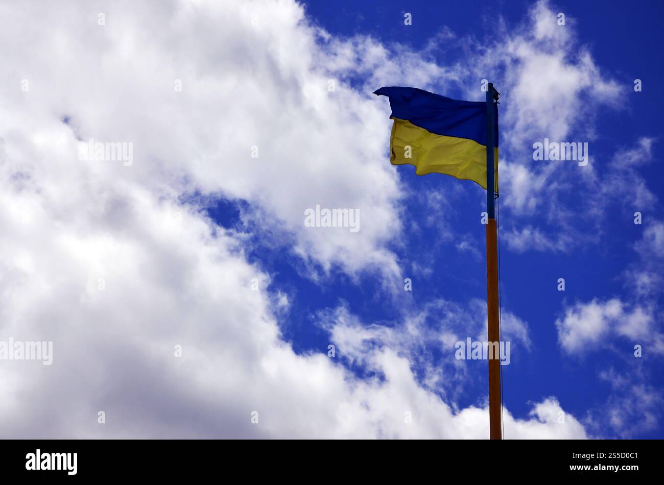 Ukrainische Flagge gegen den blauen Himmel mit Wolken. Die offizielle Flagge des ukrainischen Staates beinhaltet gelbe und blaue Farben Stockfoto
