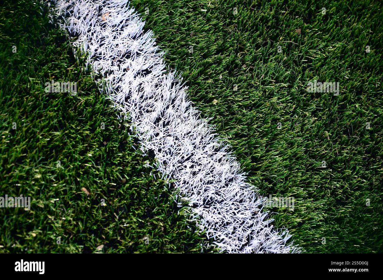 Weiße Streifen auf einem hellen grünen Kunstrasen-Fußballplatz Stockfoto