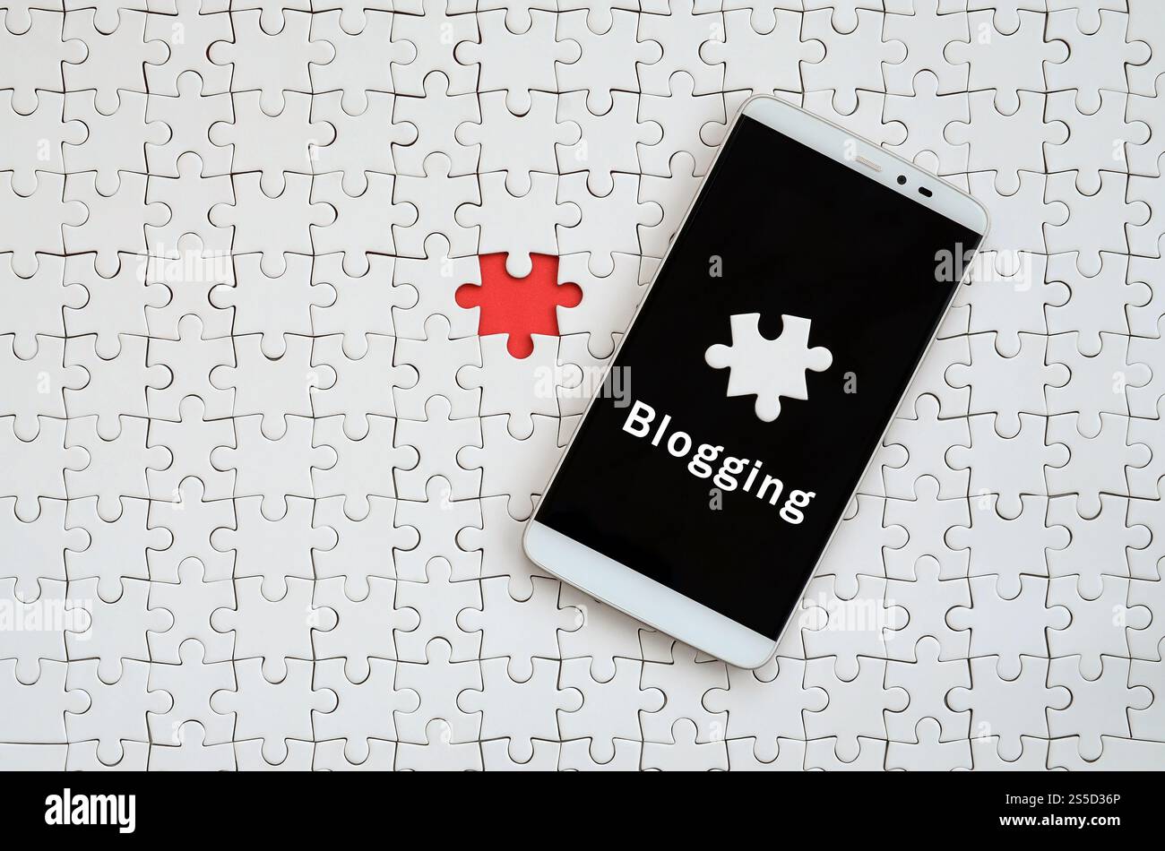 Eine moderne grosse Smartphone mit Touchscreen liegt auf einem weißen Puzzle im zusammengebauten Zustand mit Inschrift. Blogging Stockfoto