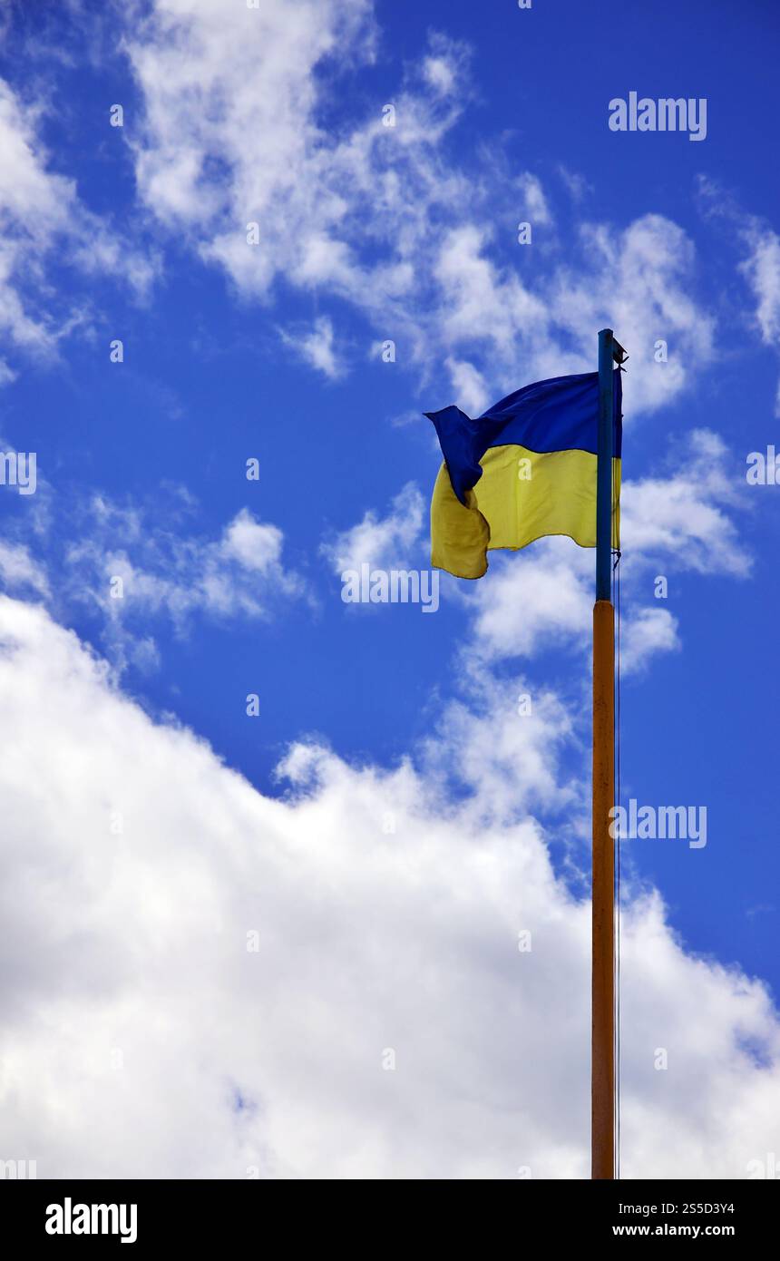 Ukrainische Flagge gegen den blauen Himmel mit Wolken. Die offizielle Flagge des ukrainischen Staates beinhaltet gelbe und blaue Farben Stockfoto