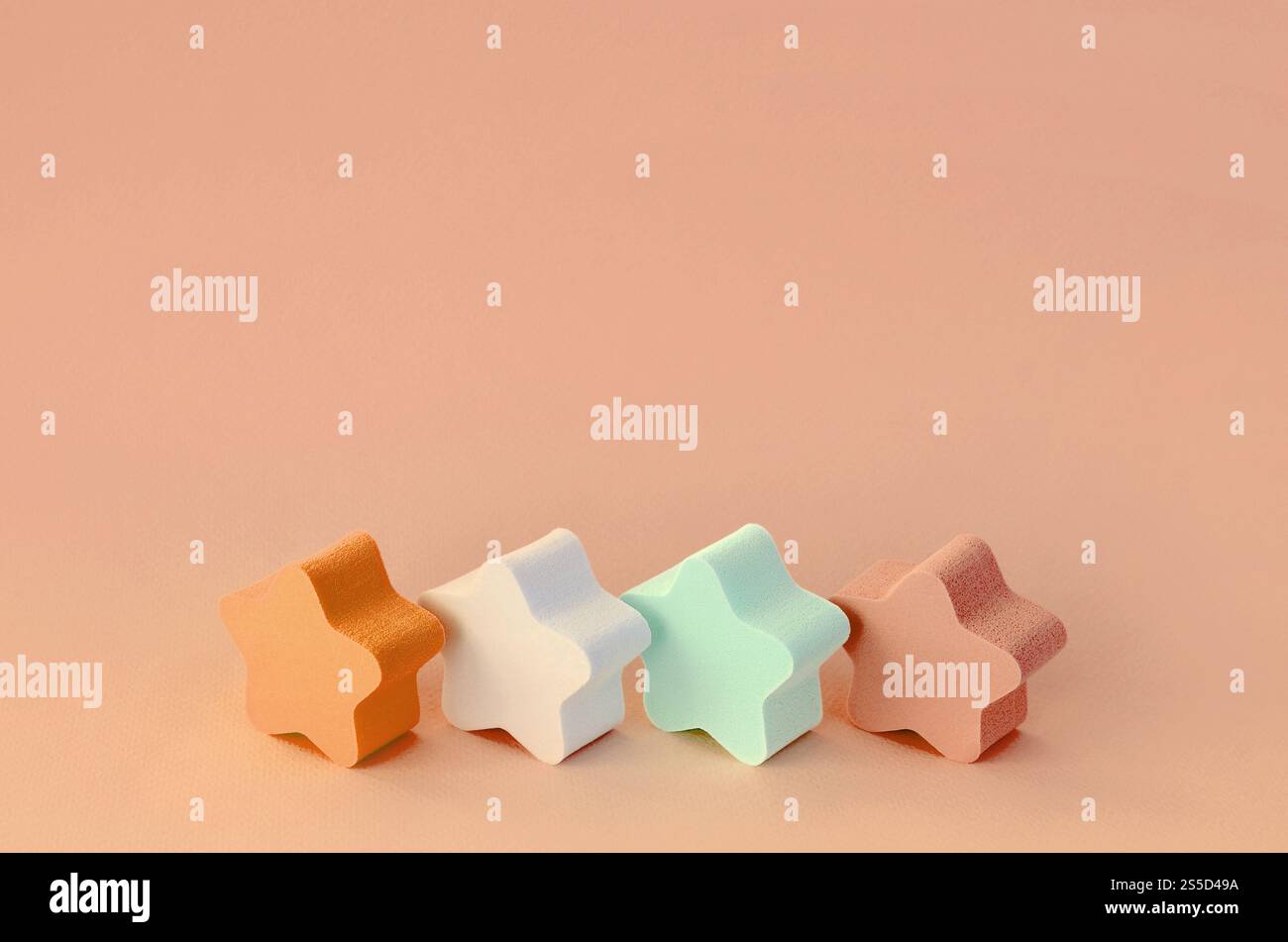 Abstrakter kosmetischer heller pastelloranger Hintergrund mit kleinen Sternen von Schwämmen. Vorlage mit Textraum. Abstrakter kosmetischer helloranger Hintergrund Stockfoto