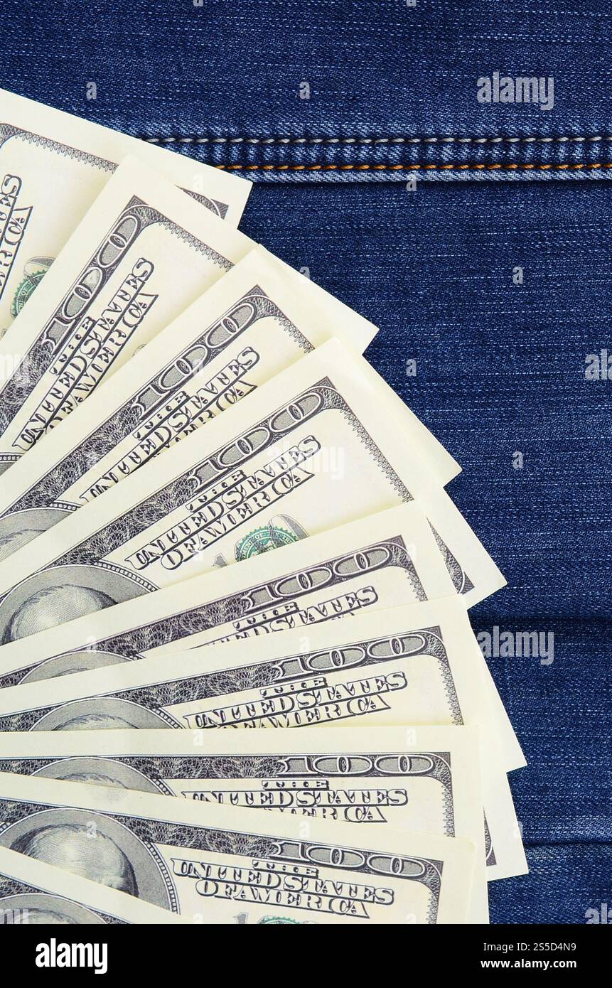 Der Fan einer Menge US-Dollar ist auf einer dunklen Jeansfläche. Hintergrundbild Stockfoto