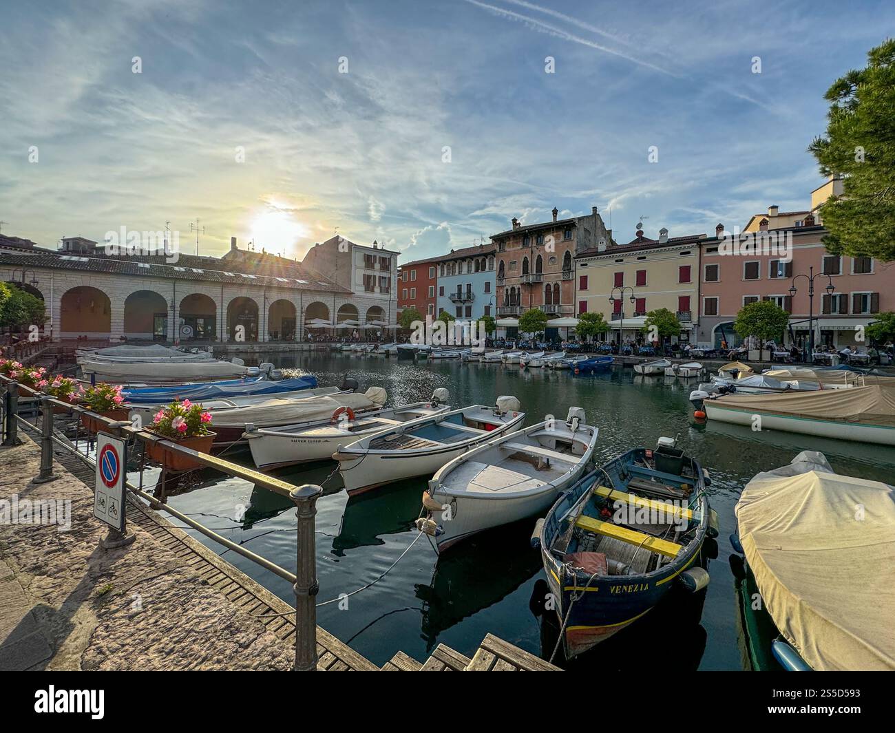 Kleine Boote in idyllischer kleiner Marina in Italien mit Sonnenuntergang und kleinen Wolken - Smartphone-aufgenommenes Stockfoto