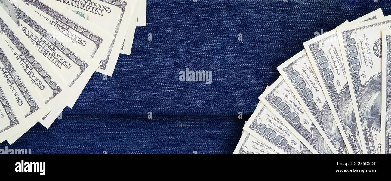 Der Fan einer Menge US-Dollar ist auf einer dunklen Jeansfläche. Hintergrundbild Stockfoto