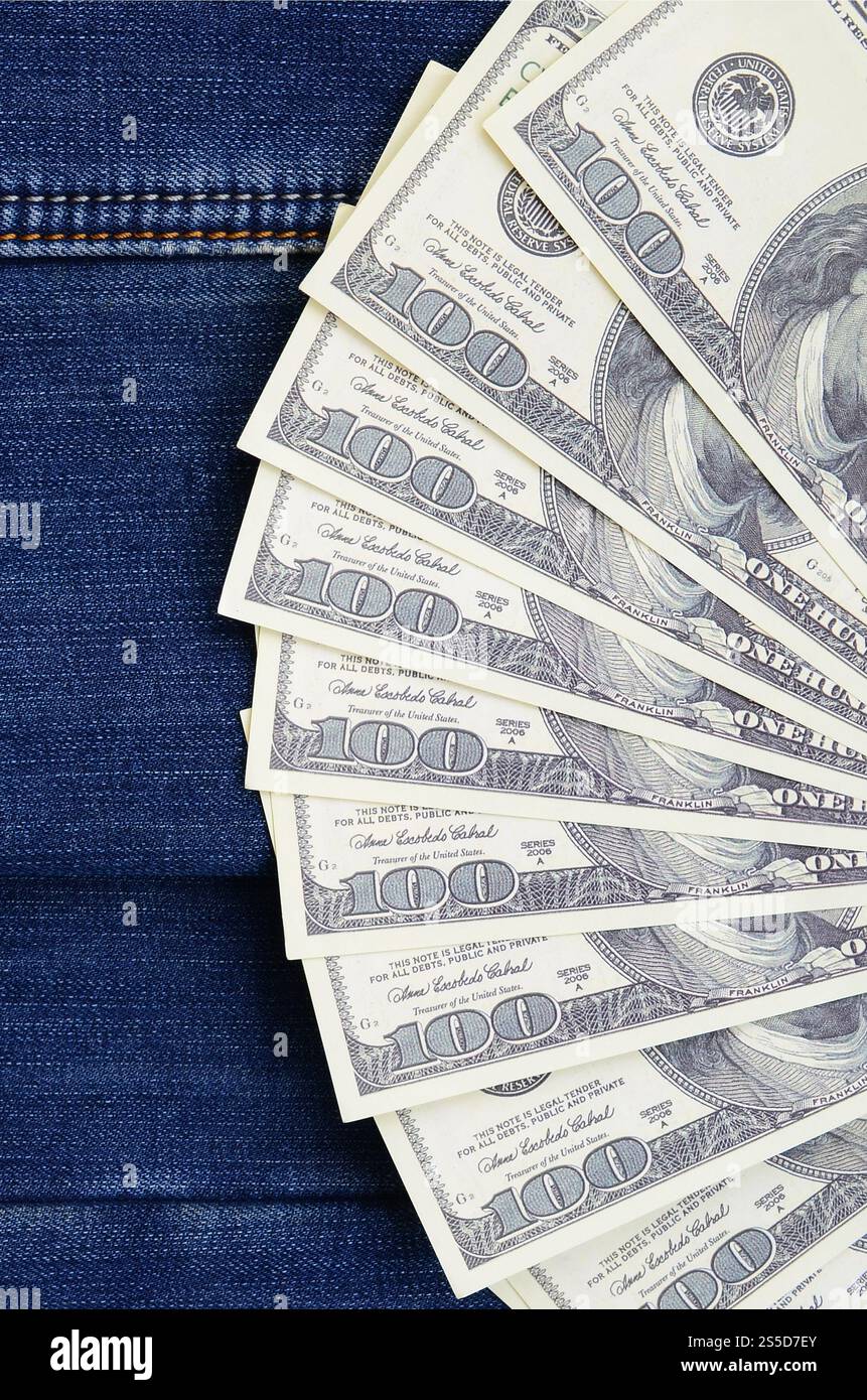 Der Fan einer Menge US-Dollar ist auf einer dunklen Jeansfläche. Hintergrundbild Stockfoto
