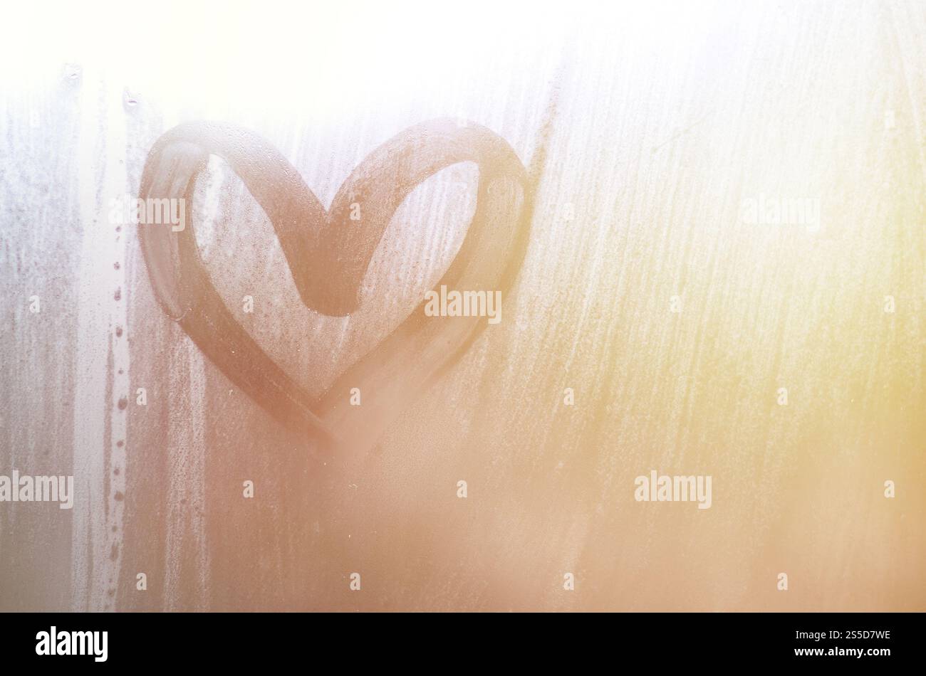 Eine herzförmige Zeichnung durch einen Finger auf einen Beschlagenen Glas im regnerischen Wetter gezeichnet Stockfoto