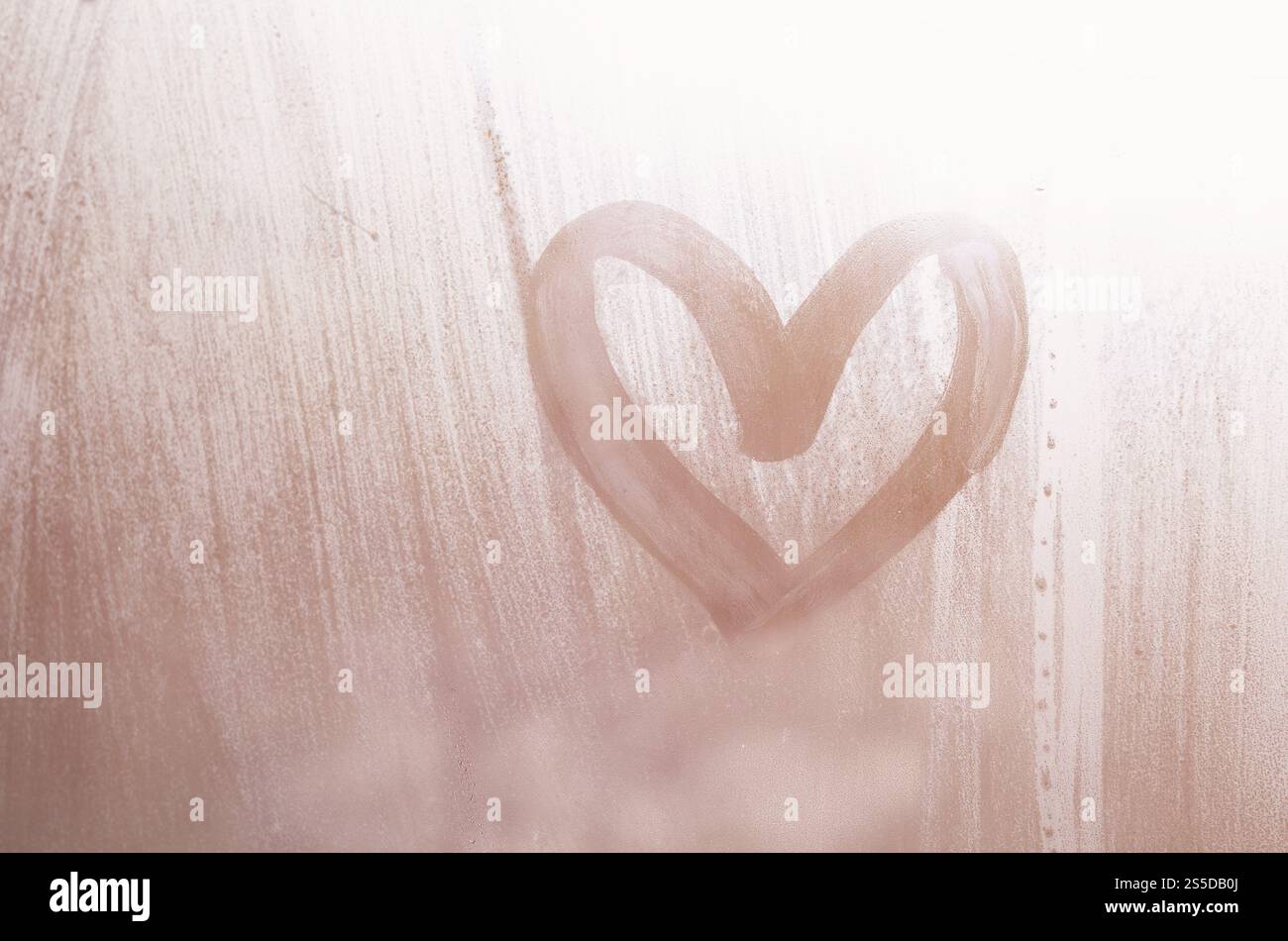 Eine herzförmige Zeichnung durch einen Finger auf einen Beschlagenen Glas im regnerischen Wetter gezeichnet Stockfoto