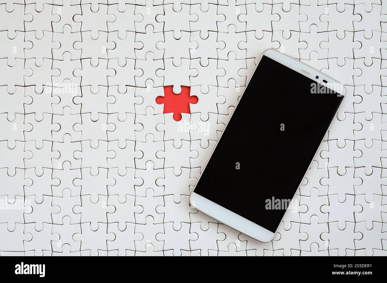 Ein modernes, großes Smartphone mit Touchscreen liegt in einem weißen Puzzle in zusammengebautem Zustand Stockfoto