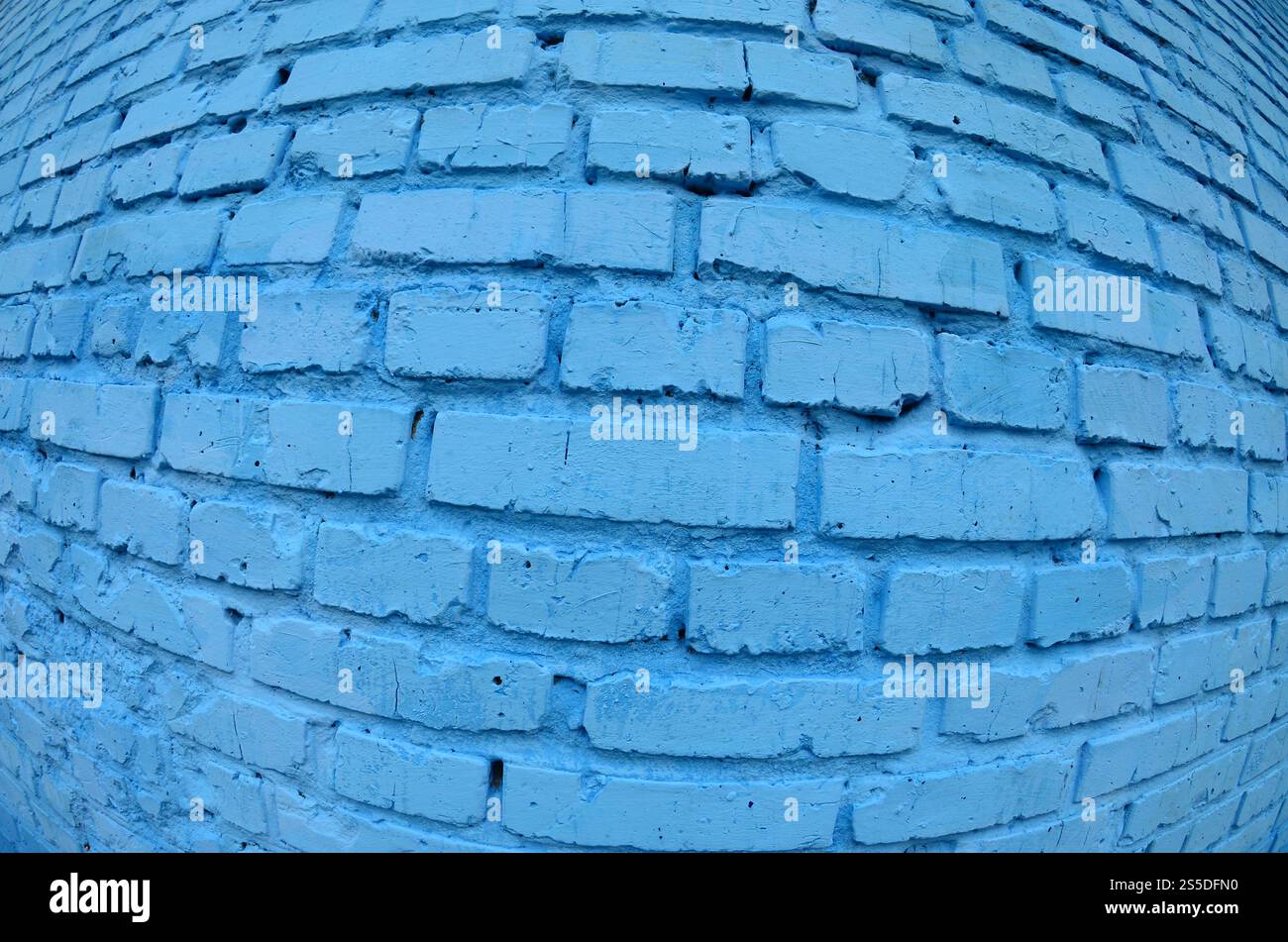 Große Backsteinwand, blau gestrichen. Fischaugenfoto mit ausgeprägter Verzerrung Stockfoto