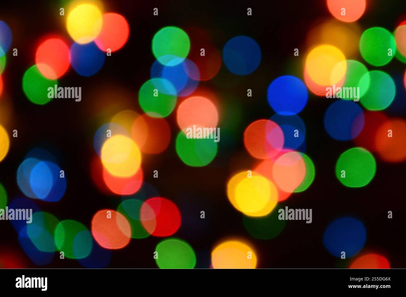 Verschwommene festliche bunte Lichter über Schwarz als Hintergrund nützlich. Alle Hauptfarben enthalten. Rot, Gelb, Grün und Blau Stockfoto