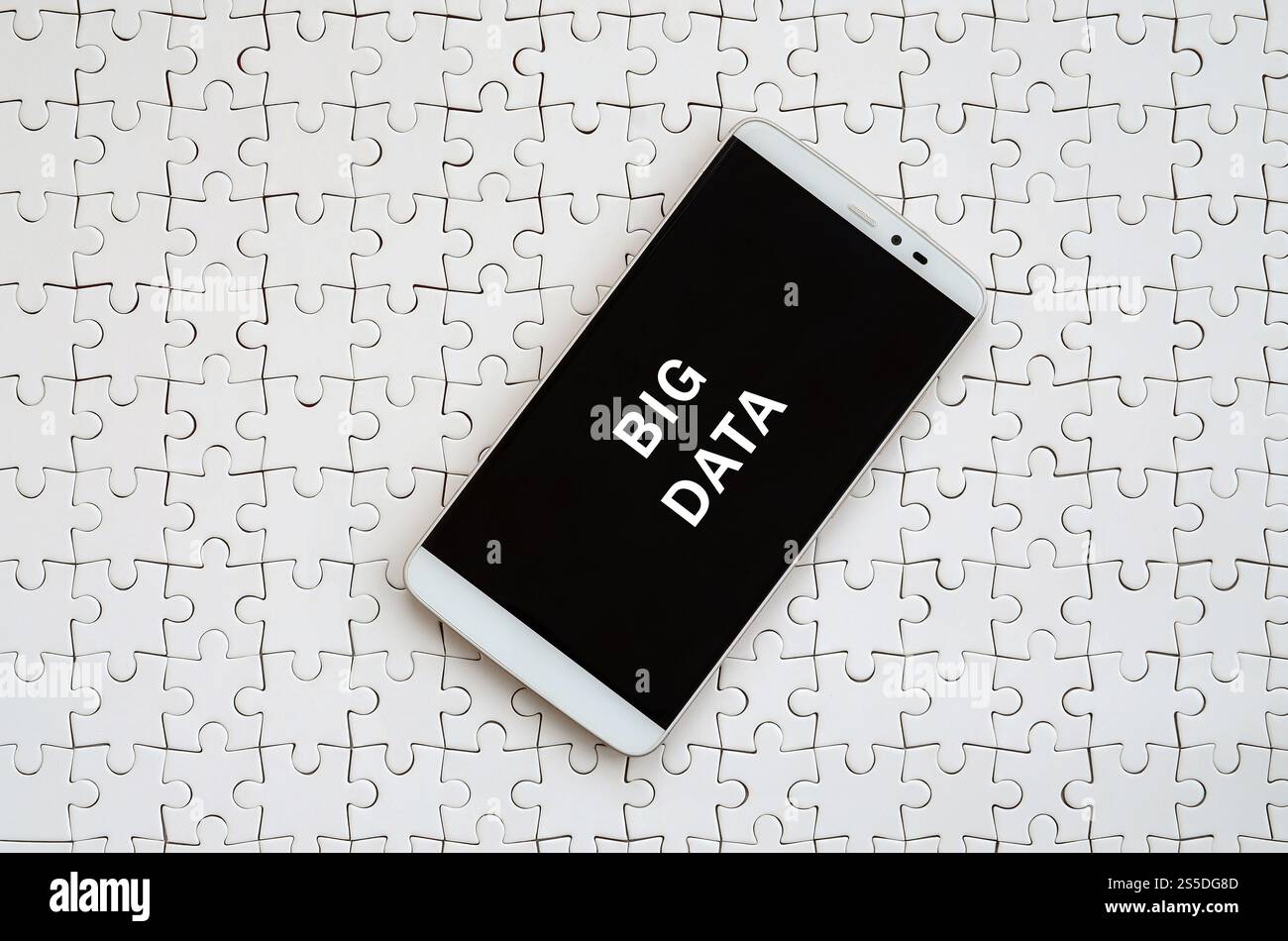 Eine moderne grosse Smartphone mit Touchscreen liegt auf einem weißen Puzzle im zusammengebauten Zustand mit Inschrift. Grosse Daten Stockfoto