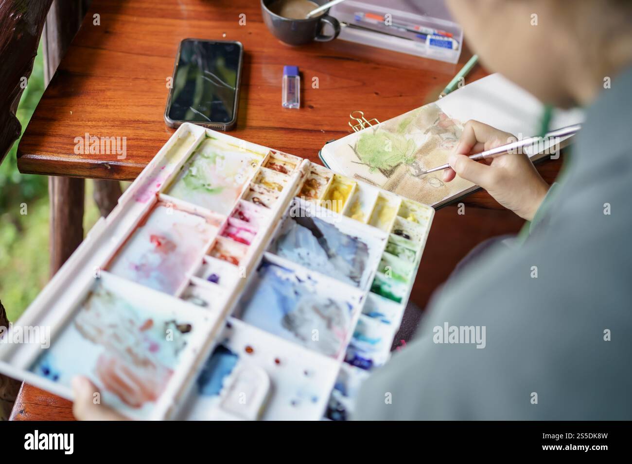 Student im Kunststudio. Hand haltender Künstler Pinsel mischen FarbÖlgemälde auf Palette Kunst Kreativität und Menschen Konzept. Stockfoto