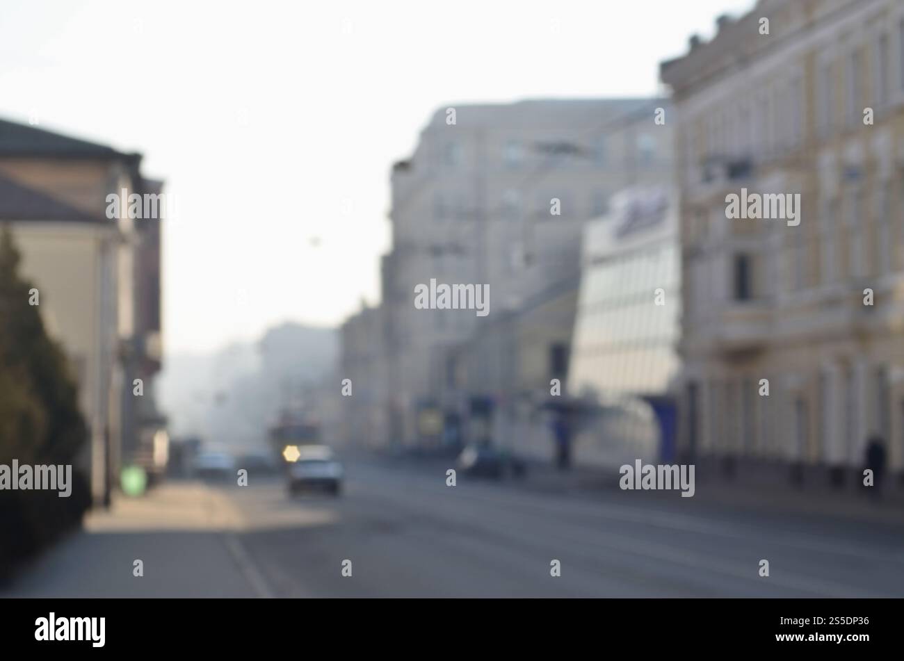 Die verschwommene Landschaft der Stadtstraßen mit fahrenden Autos und Straßenbahnen an einem nebeligen Morgen. Künstlerische Rezeption eines verschwommenen Landschaftsfotos mit Bokeh Stockfoto