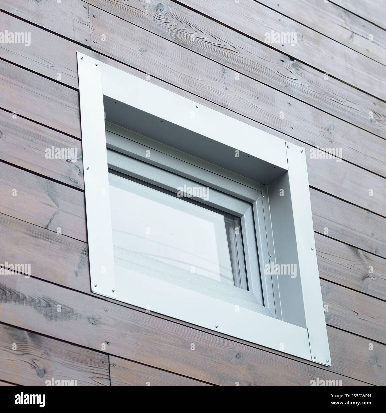 Kunststoff-PVC-Fenster in moderner Passivholzfassadenwand. PVC-Fenster sind die größte Energieeffizienz im Haus. Kunststoff-PVC-Fenster neu Stockfoto