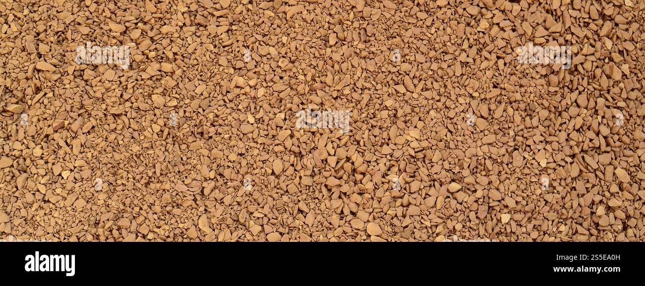 Textur des gemahlenen Kaffees in Form von vielen kleinen, dunkelbraunen Kieseln Stockfoto