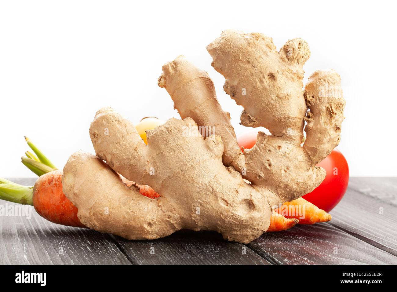 ingwer auf schwarzem Holzhintergrund auf weiß Stockfoto