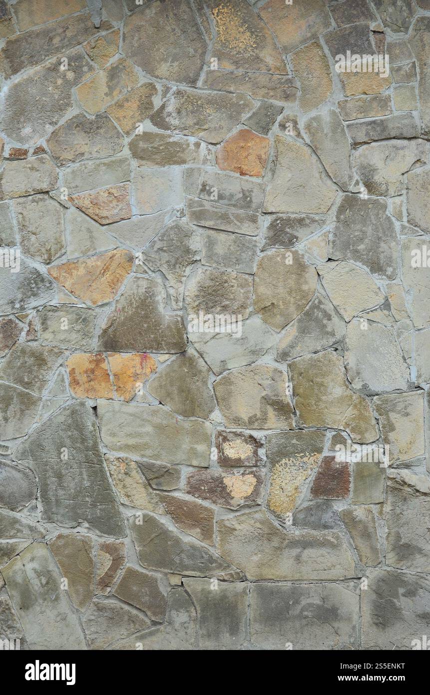 Steinmauerhintergrund - Bauelement. Textur einer dicken und starken Wand aus rauen Steinen verschiedener Formen und Größen. Verwittert und alt befleckt Stockfoto Steinmauerhintergrund - Bauelement. Textur einer dicken und starken Wand aus rauen Steinen verschiedener Formen und Größen. Verwittert und alt befleckt Stockfoto
