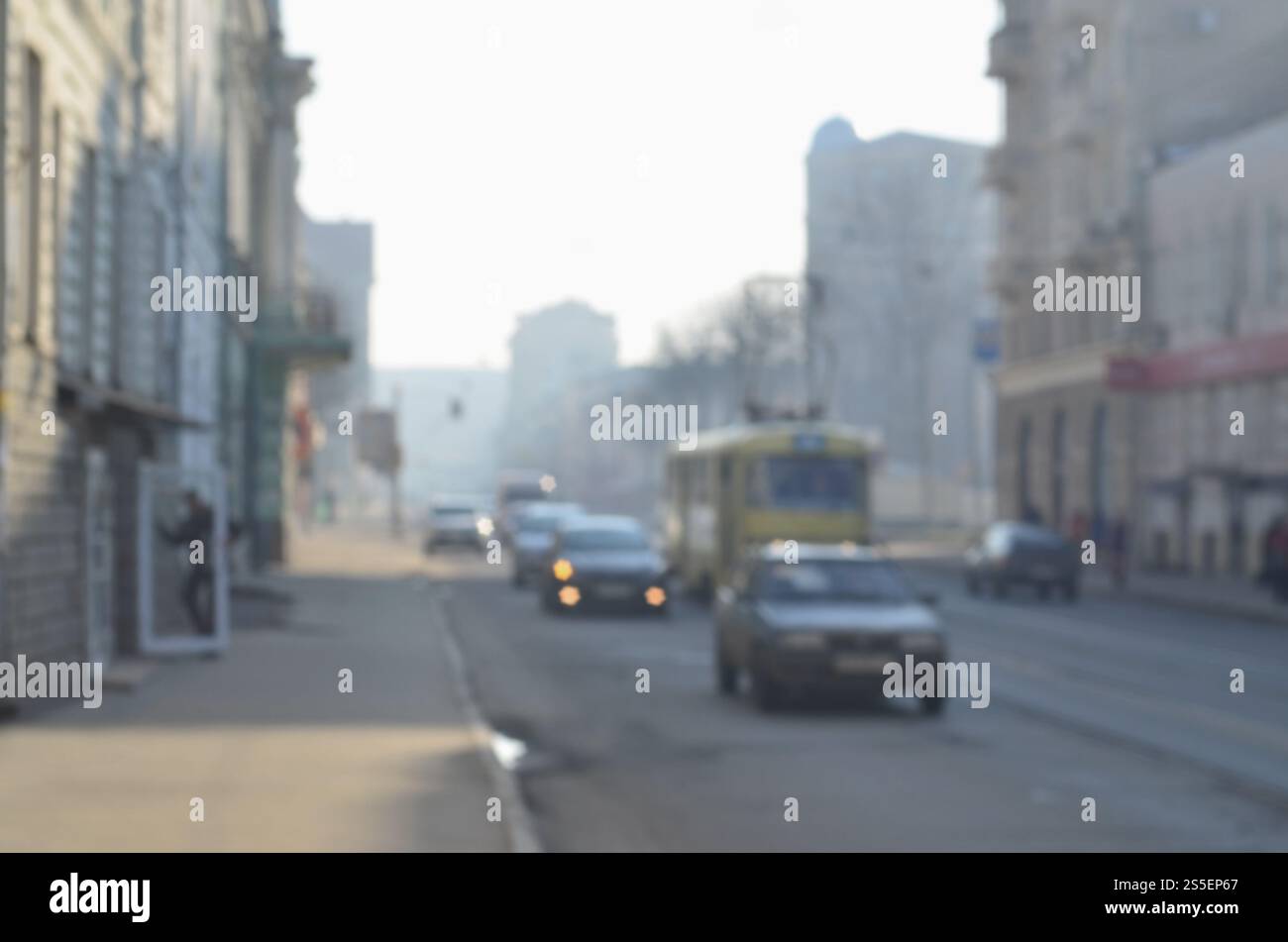 Die verschwommene Landschaft der Stadtstraßen mit fahrenden Autos und Straßenbahnen an einem nebeligen Morgen. Künstlerische Rezeption eines verschwommenen Landschaftsfotos mit Bokeh Stockfoto