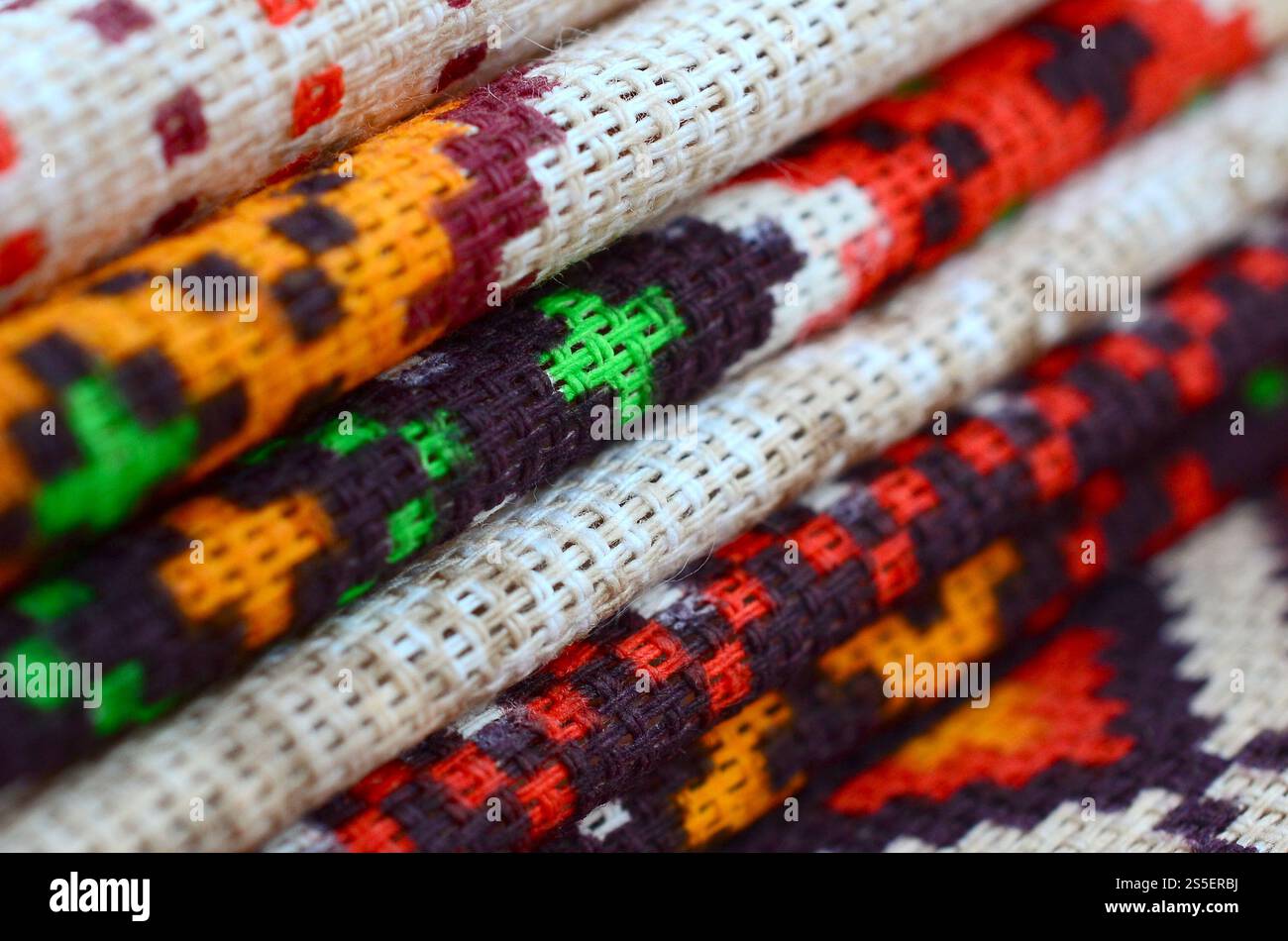 Stapel traditioneller ukrainischer Stickmuster auf Textilgewebe. Gestricktes Canvas mit farbigem Pixeldesign. Stapel traditioneller Produkte Stockfoto