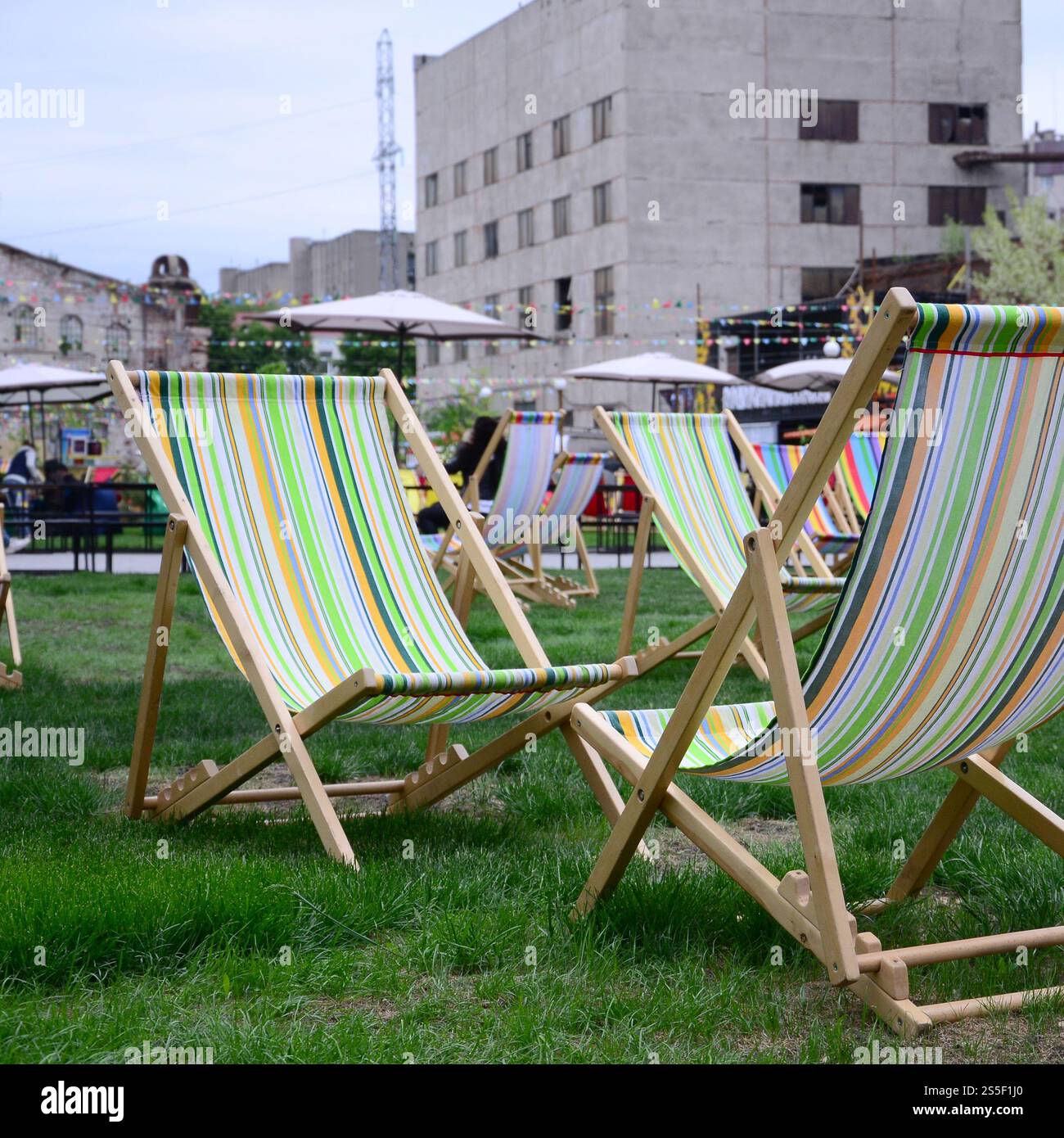 Liegestühle auf einem Rasen. Ruhen Sie sich auf dem Festival aus, im Urlaub. Gartenliegen auf grünem Gras. Gartenbett zum Sonnenbaden und Ausruhen. Sommerstuhl. Chaise Stockfoto