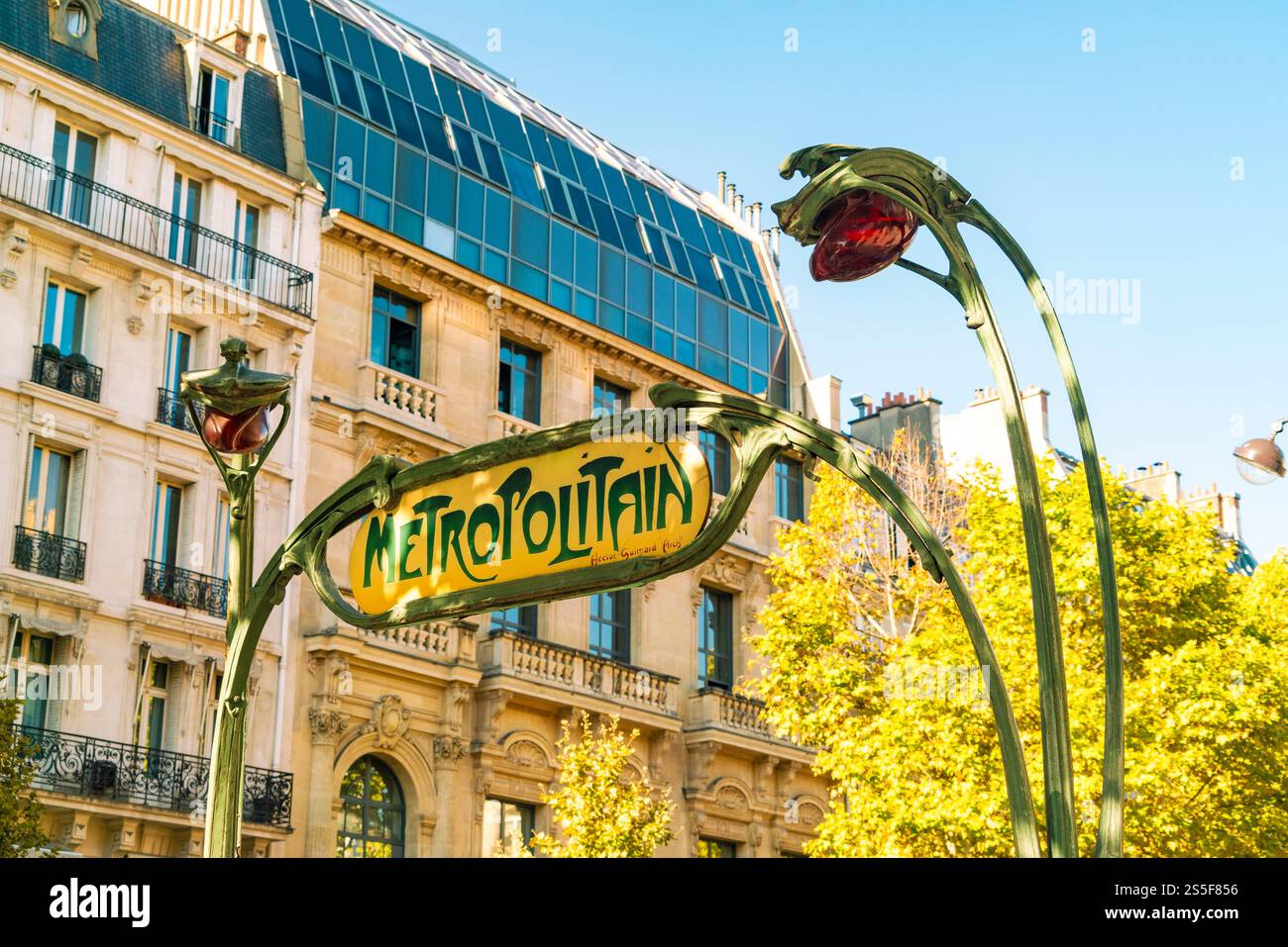 Vintage Metropolitain Schild in Paris mit klassischen Straßenlaternen und einem modernen Gebäude im Hintergrund an einem sonnigen Tag, Frankreich Stockfoto
