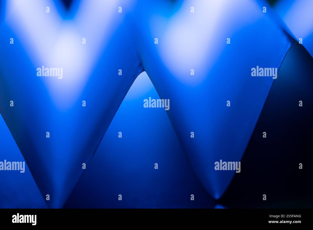 Geschwungene Formen in leuchtendem Blau und Schwarz verschmelzen harmonisch und schaffen eine ansprechende abstrakte Komposition, die den Betrachter zum Entdecken einlädt Stockfoto