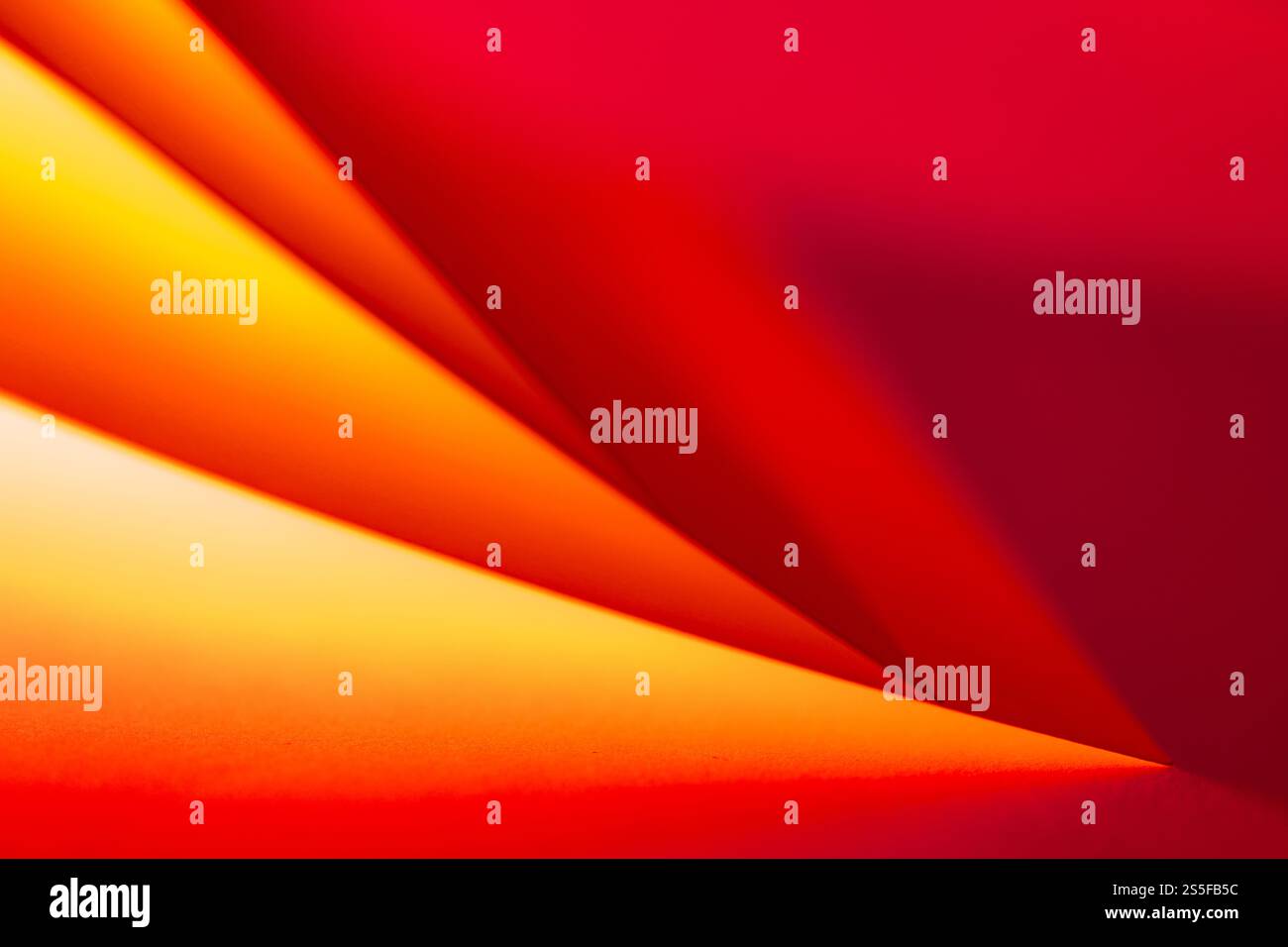 Geschwungene Formen in leuchtenden Rot- und Orangetönen verschmelzen harmonisch und schaffen eine ansprechende abstrakte Komposition, die den Betrachter zum Erkunden einlädt Stockfoto