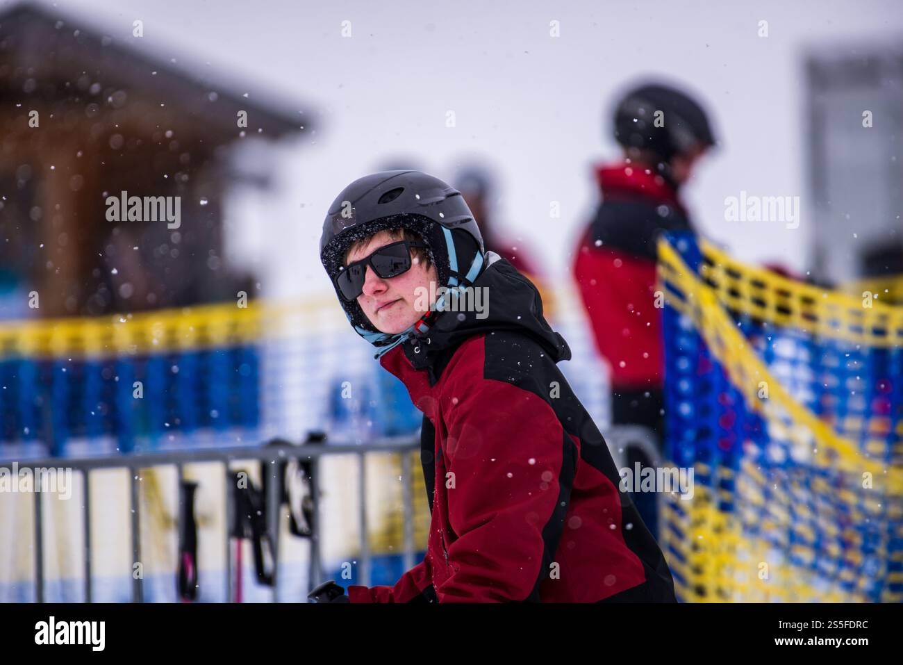 Ein junger Mann läuft auf einen Skilift in einem Skigebiet in Deutschland zu Stockfoto