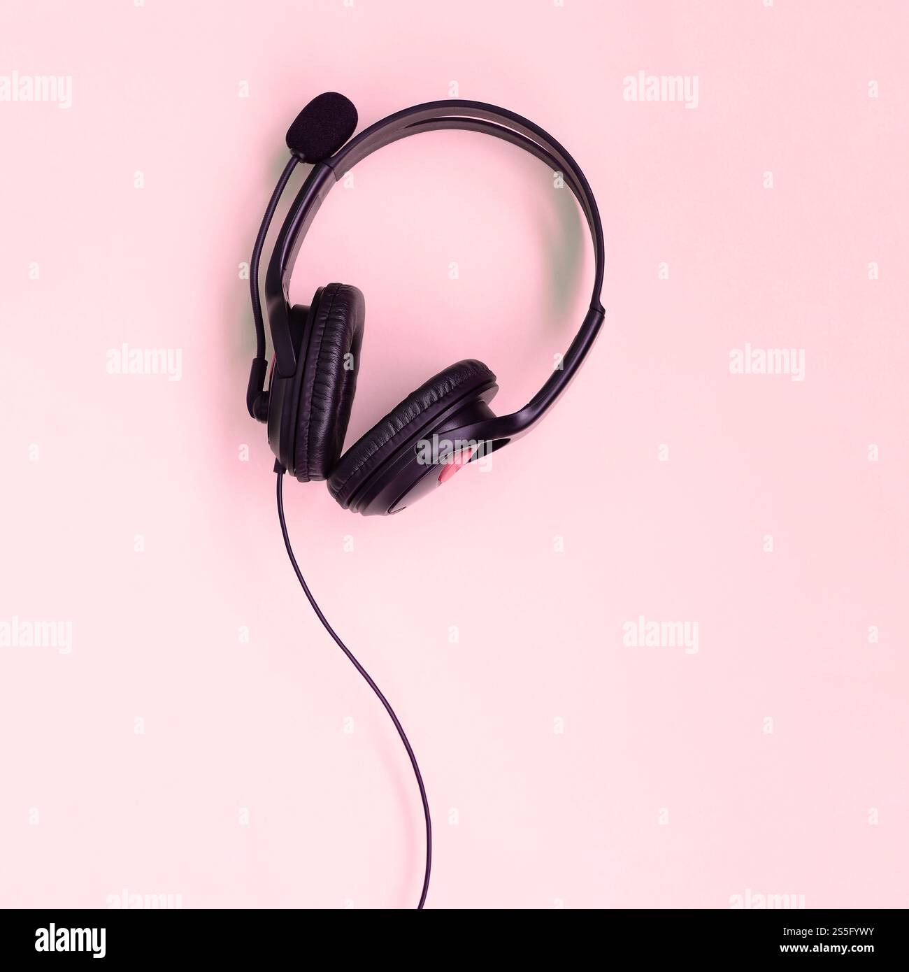 Schwarze Kopfhörer liegen auf einem farbenfrohen, pastellrosa Hintergrund. Musikvergnügen. Draufsicht mit flacher Lage. Musikvergnügen. Schwarze Kopfhörer Stockfoto