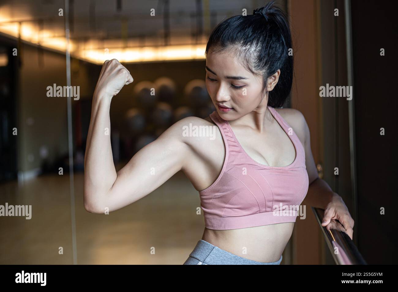 Fitness-Frauen zeigen im Fitnessstudio Armmuskeln. Stockfoto