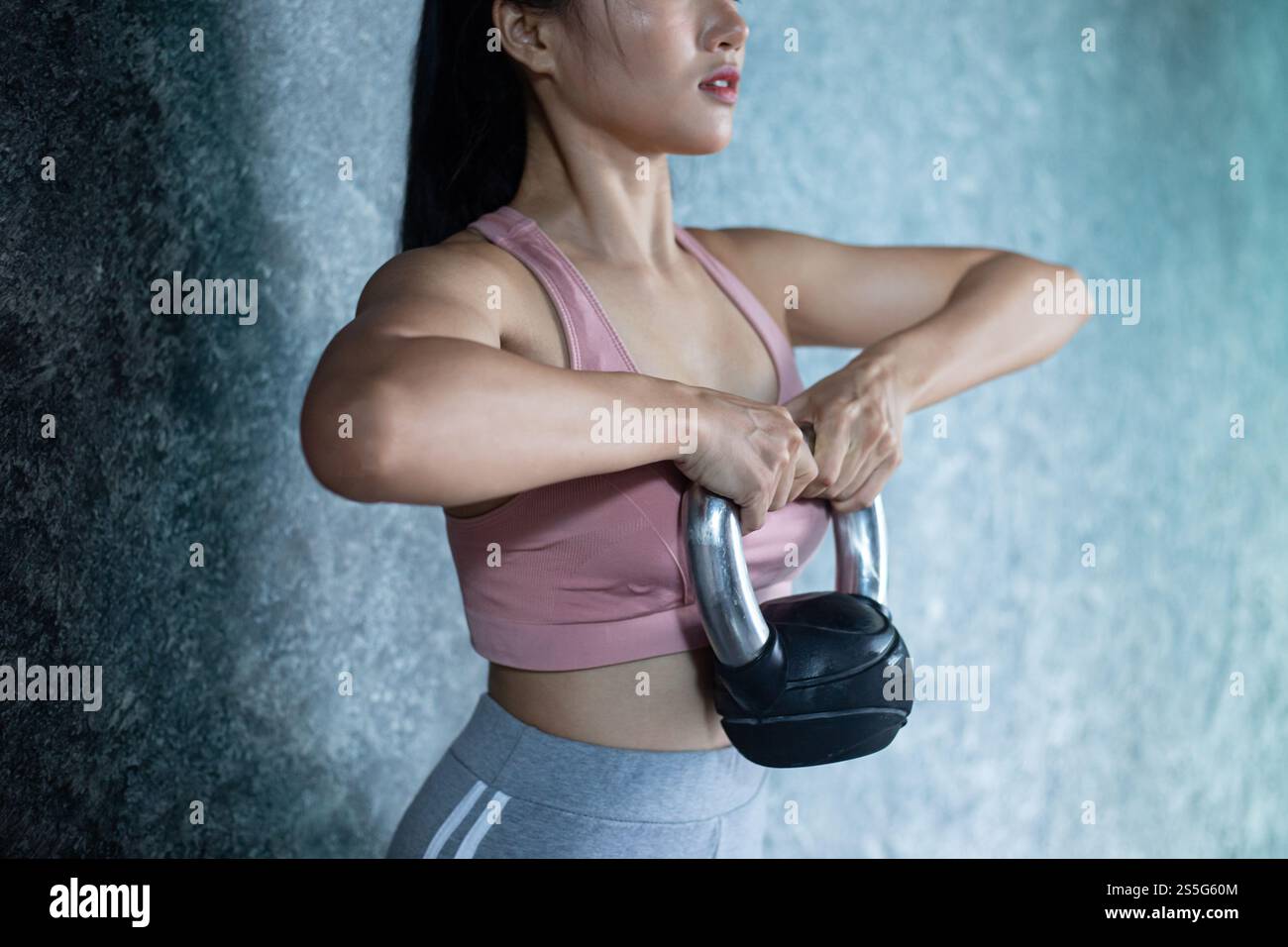 Asiatisches Mädchen, das mit der Kettlebell im Fitnessstudio trainiert. Stockfoto